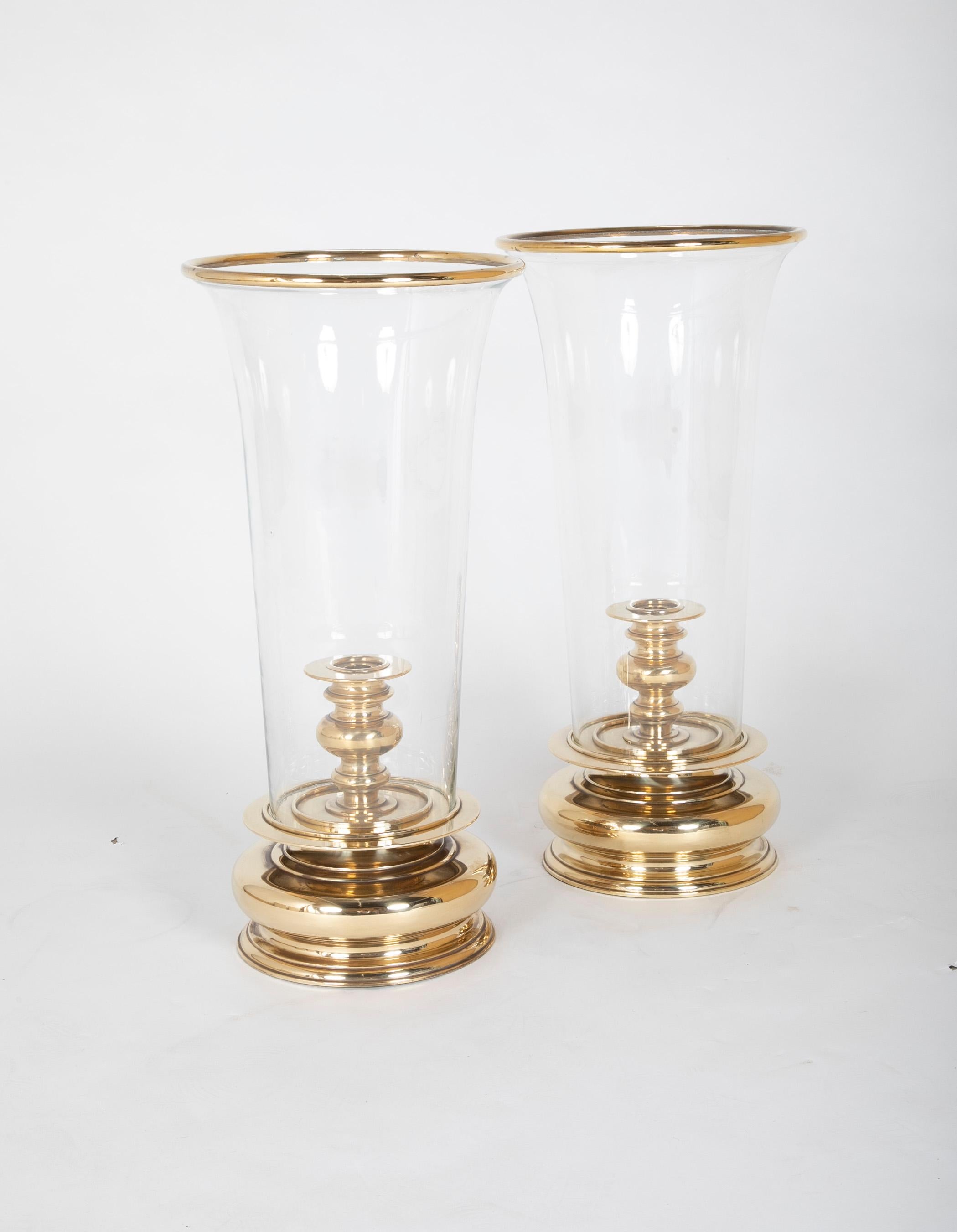 Impressive pair of large scale brass hurricane lamps with brass rimmed hand blown glass shades. The bases turned brass in a Dutch Baroque style but with a very modern look. Great for traditional or contemporary interiors. At over 2 feet tall and a