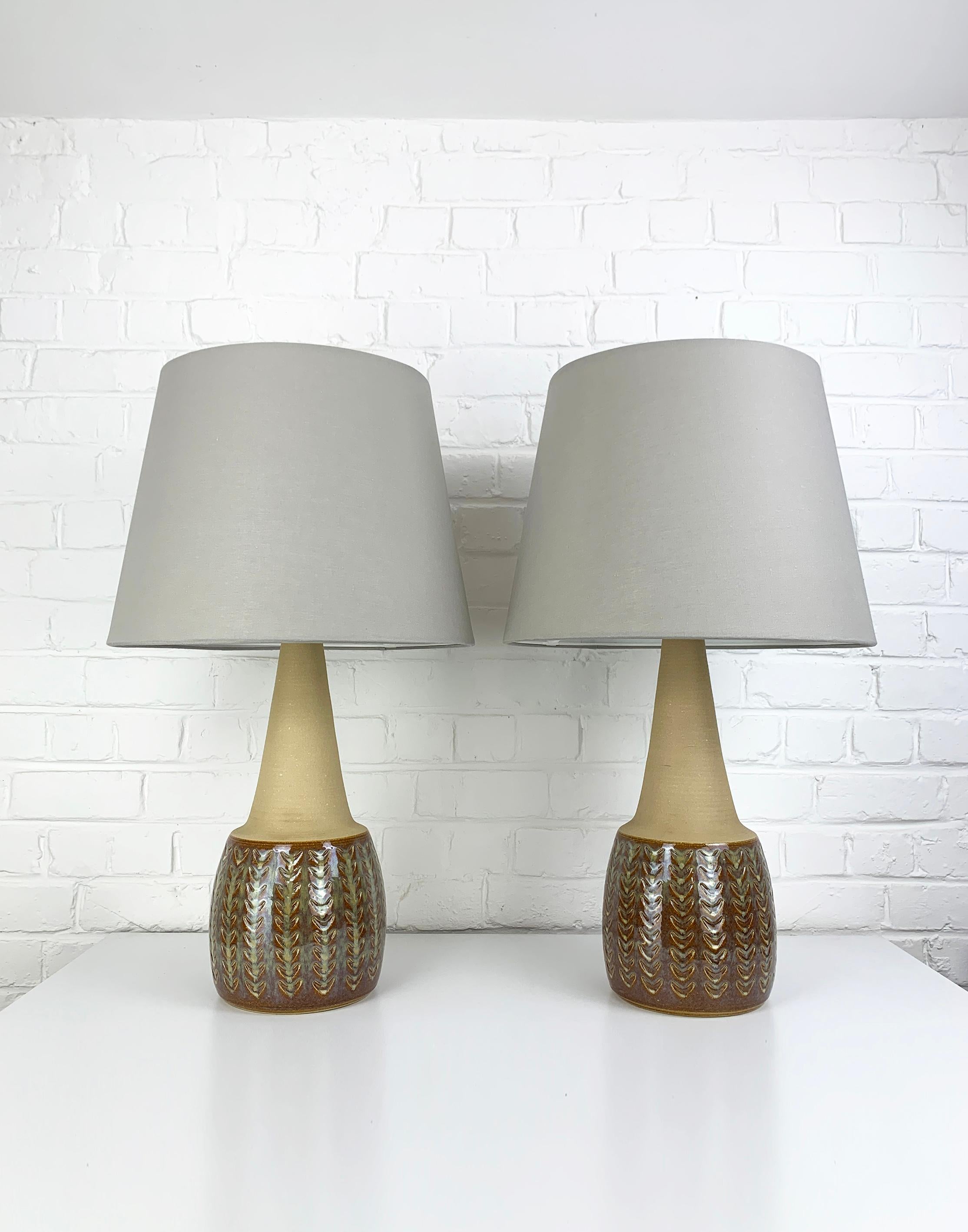 Pair of big Danish Mid-Century stoneware table lamps of the 1960-70s.   

The bottom part of the lamps is glazed in brown with olive green-ochre-yellowish accents and decorated with a 