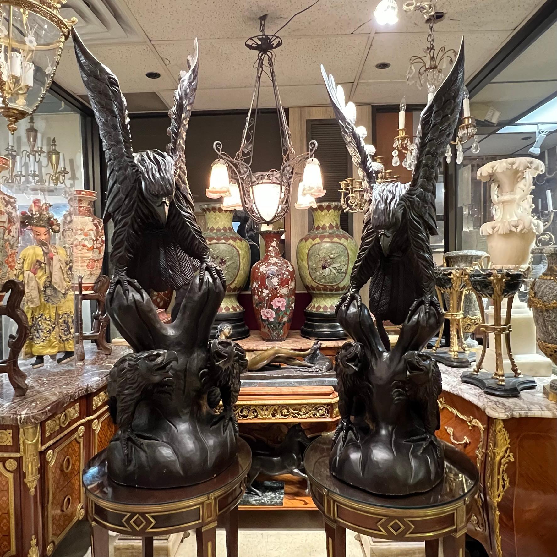 Pair of monumental carved wood statues of exceptional quality, depicting eagles standing on top of tree trunks.