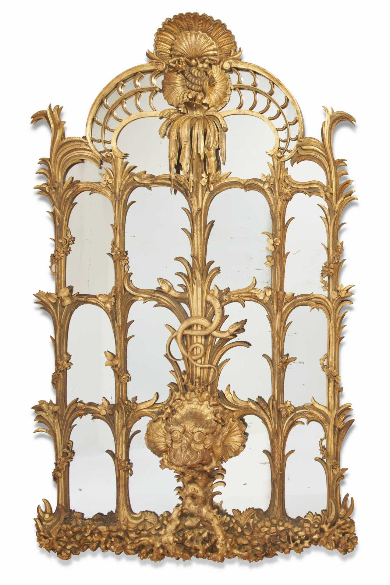Our pair of monumental European giltwood mirrors each measure approximately 50 by 84 inches (213.5 by 127 cm), and feature extraordinary carved giltwood designs of marine life including seashells of various shapes, snakes, dolphins and serpents. 