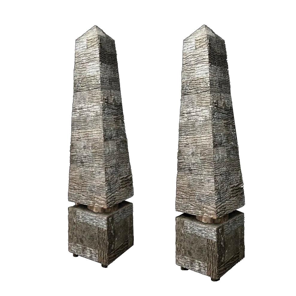 Pair of monumental obelisks hand-crafted by artist Raleigh Adams. They are built from poplar bark sourced in the Appalachian Mountains, rise on sturdy locust feet, and lift from their base with a solid locust disc—bringing ancient form into a