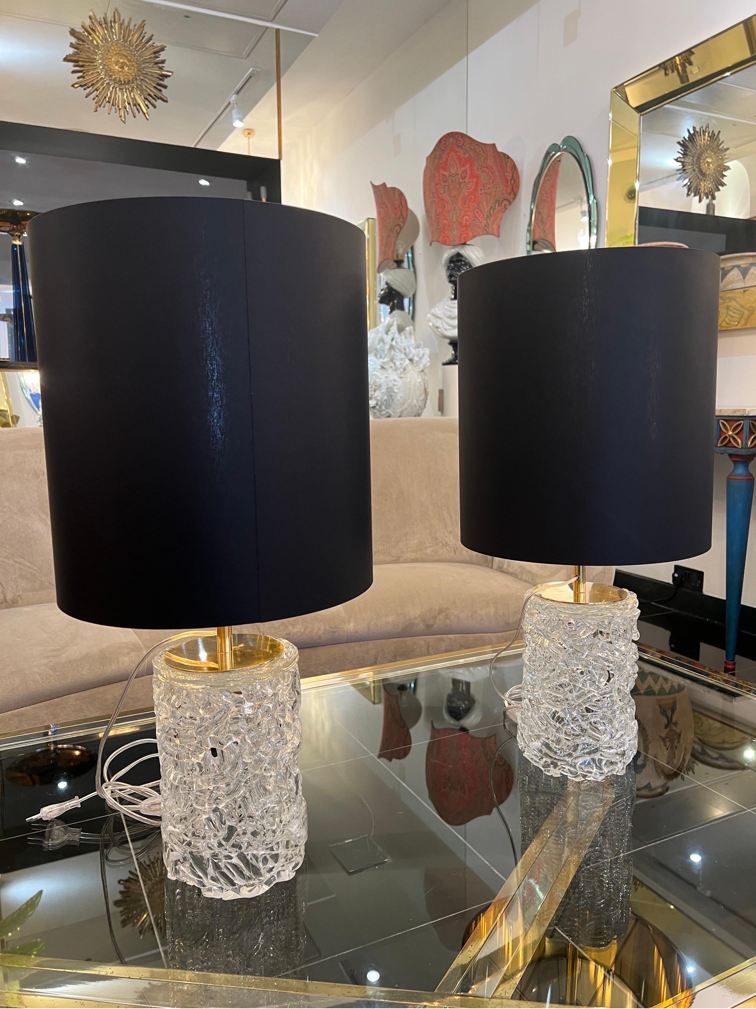 Pair of table lamps with intricately designed twisted clear Murano glass mounted on solid brass fixtures. Black linen shades with gold lining each measuring 35cm (14in) also included. 
The height of the base without shade is 43cm (17in) 