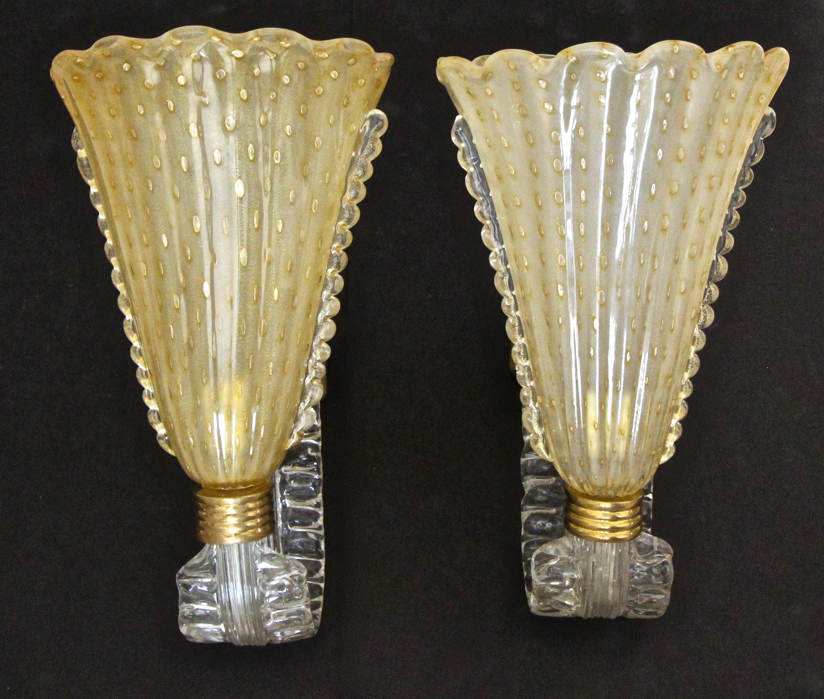 Pair of Murano art glass wall sconces. Italian hand blown yellow colored shades with bullicante bubbles and gold inclusions mounted on S-curve clear glass arms. Mounted on brass backplate with brass fittings. Newly wired.