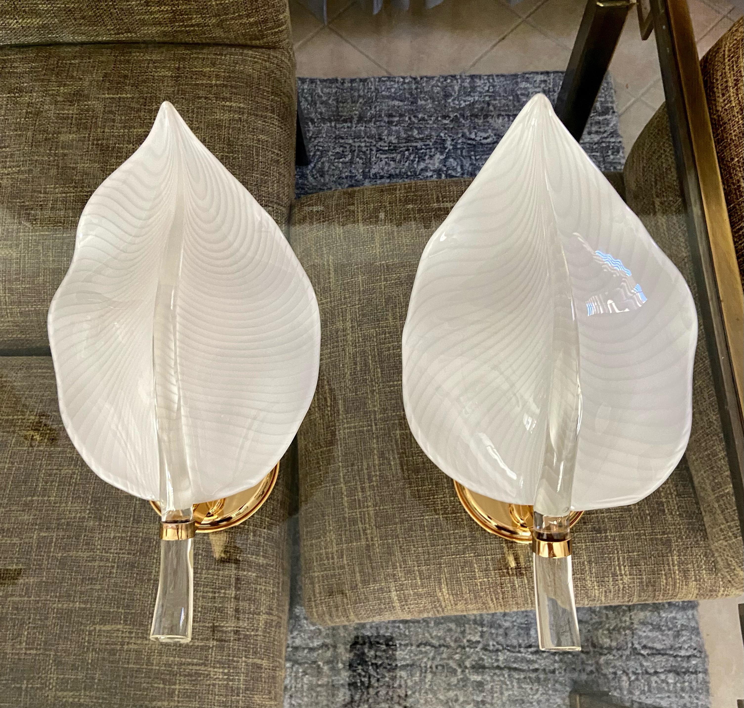 Pair of large murano handblown white and clear leaf wall sconces mounted on brass finish backplates by Franco Luce. Features thick clear middle stem and fine veining effect on white leaf section. Each uses single regular A base size bulb. wired for