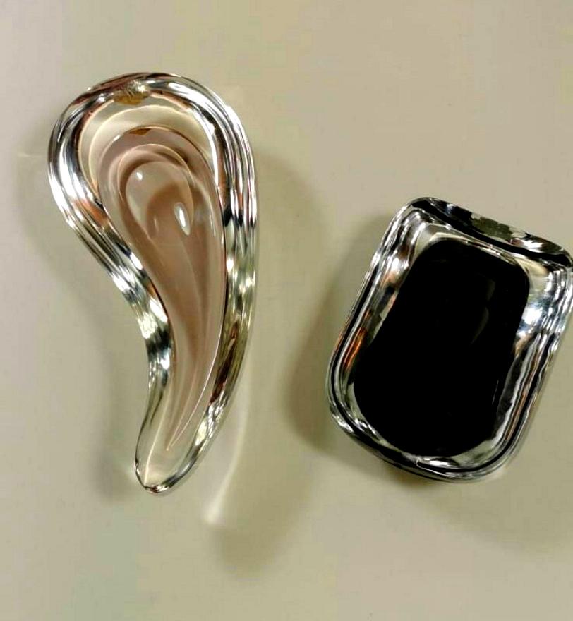 Pair of solid glass ashtrays; their well-proportioned shapes have a soft, elegant and original design one has a strong black color in contrast with the transparent edge, the other is pink that fades gently towards the crystalline; were executed in