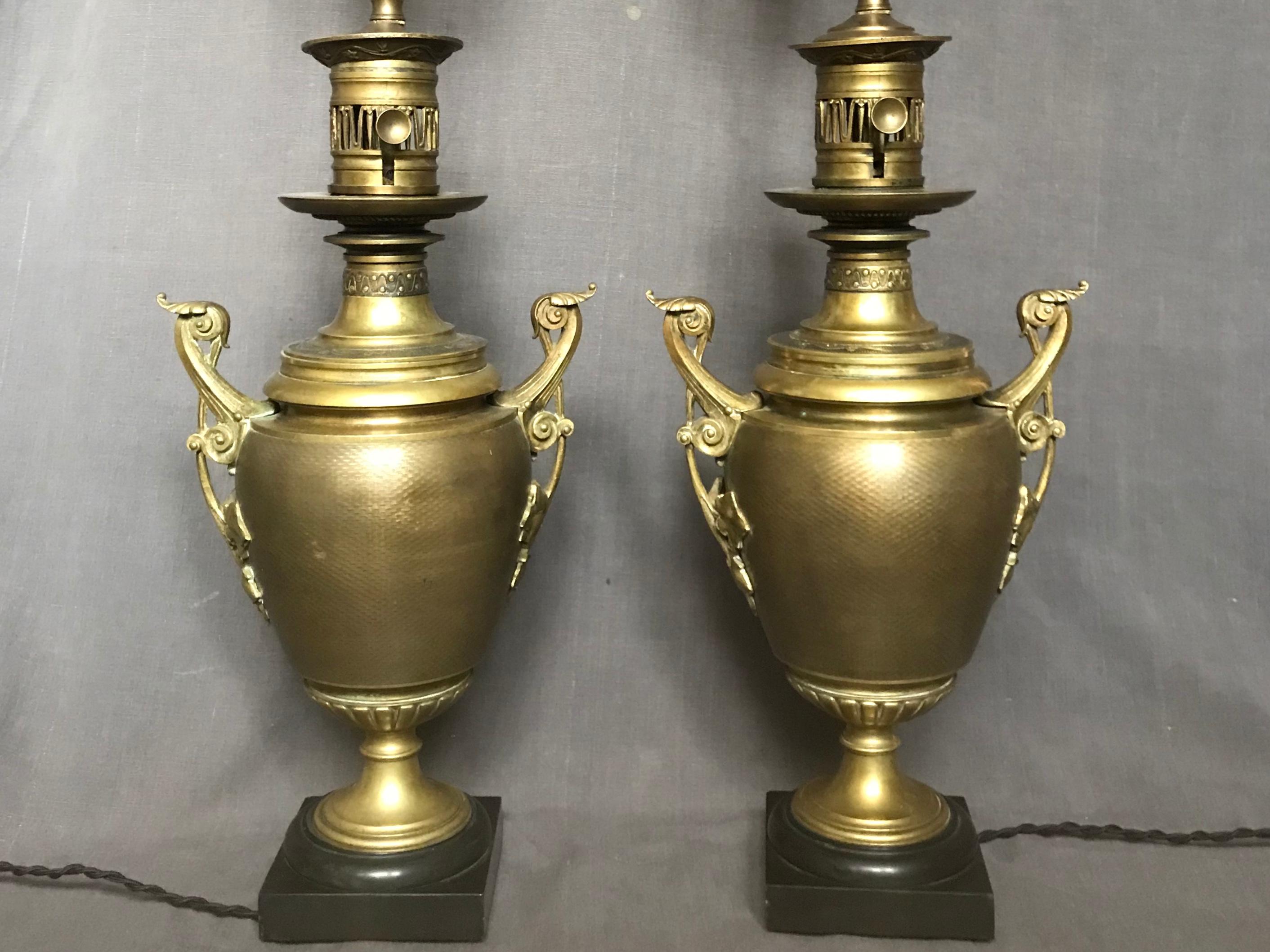 Pair of Napoleon III lamps. Pair of engine turned period brass lamps previously converted from oil to electric on black bases; newly rewired with black silk cords. France, late 19th century.
Dimensions: 9