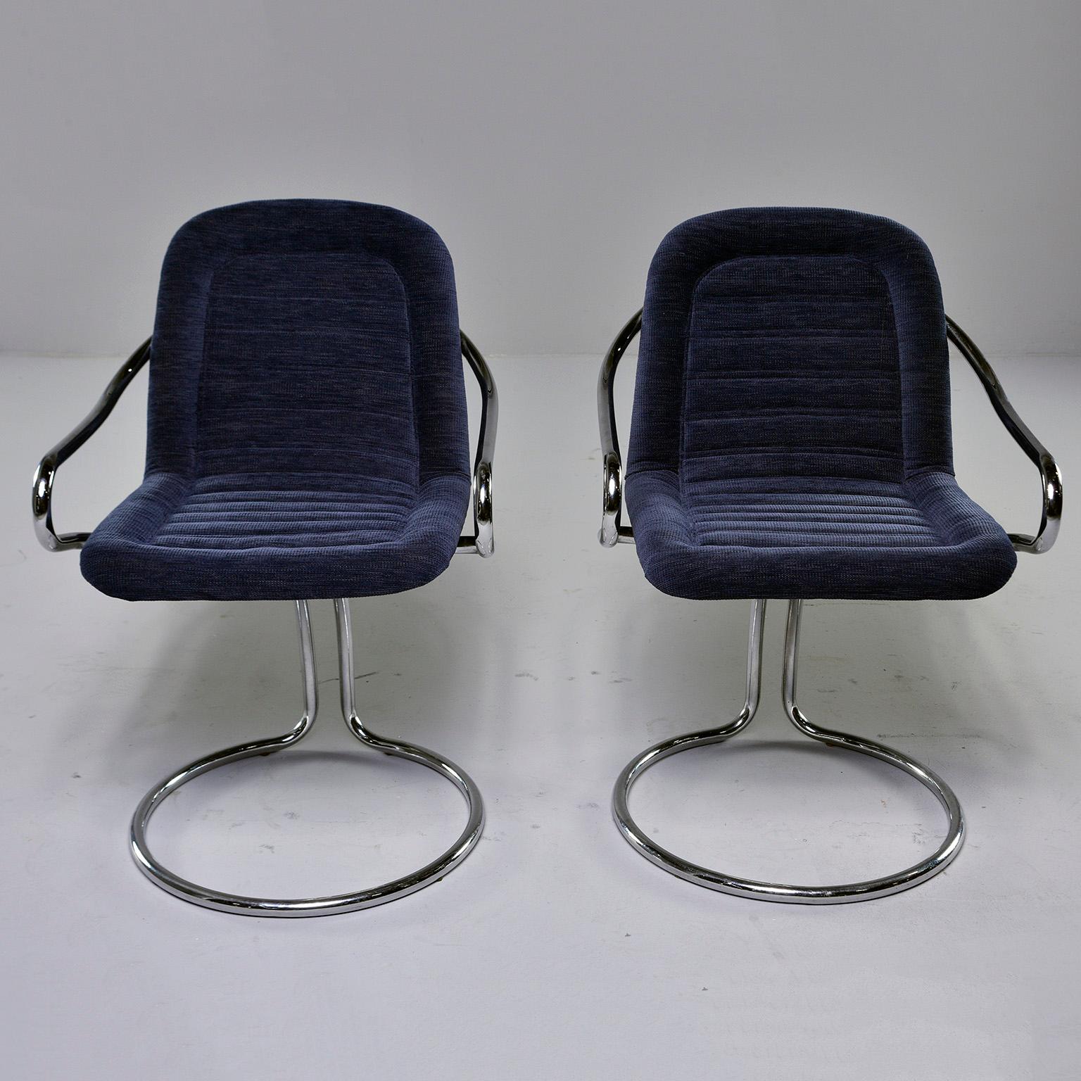 Found in Italy, this pair of circa 1970s armchairs feature polished chrome frames with a circle form base and curved arms. Seats are scoop shaped with new navy blue chenille upholstery. The base gives these chairs a bit of bounce and give. Unknown