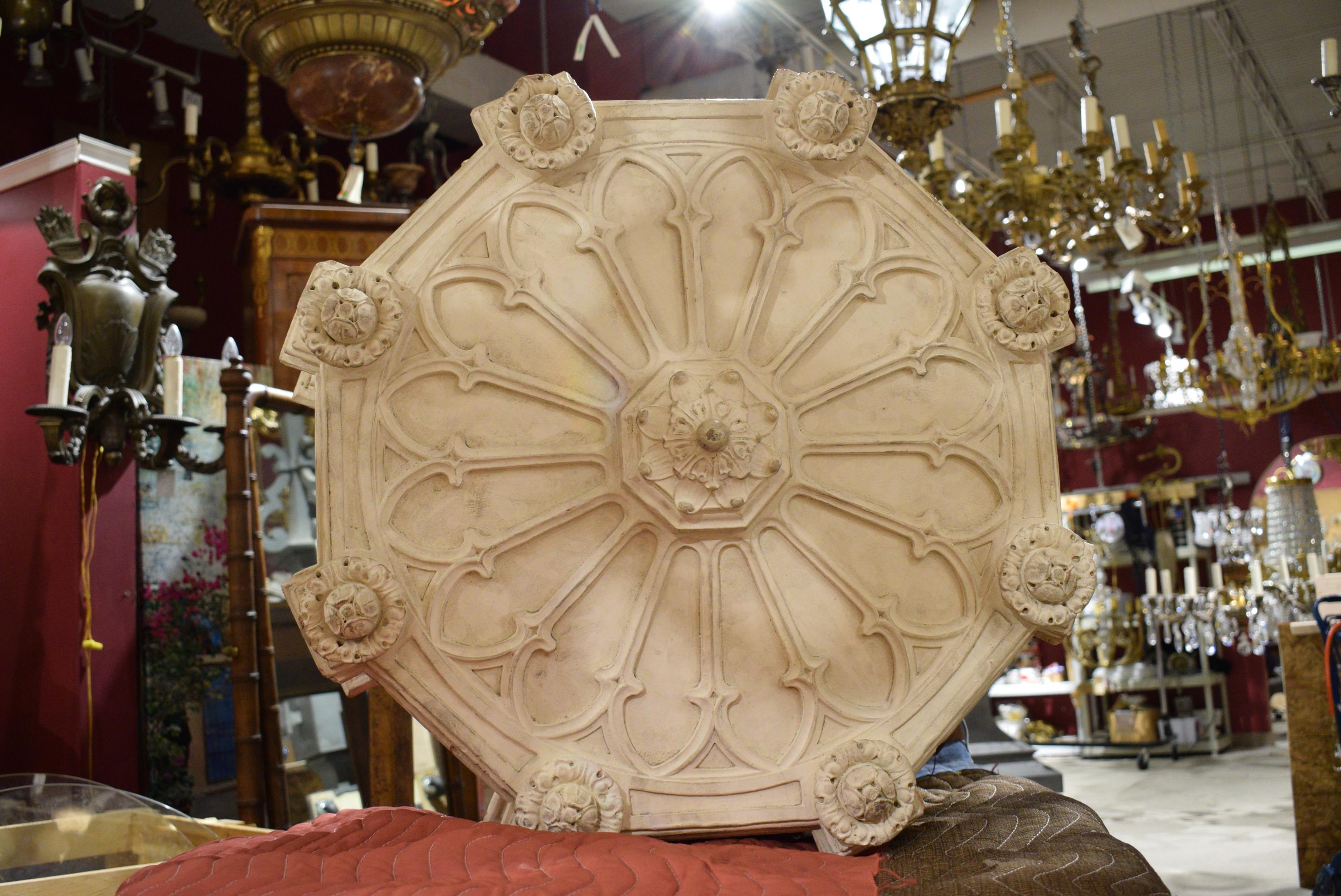 Likely American, circa 1910. Neo-Gothic or Tudor style cream painted cast terracotta four-light pendants, having an octagonal body with paneled pointed arches, protruding rosette blocks with acanthus finials, suspended by chains with afoliate plate.