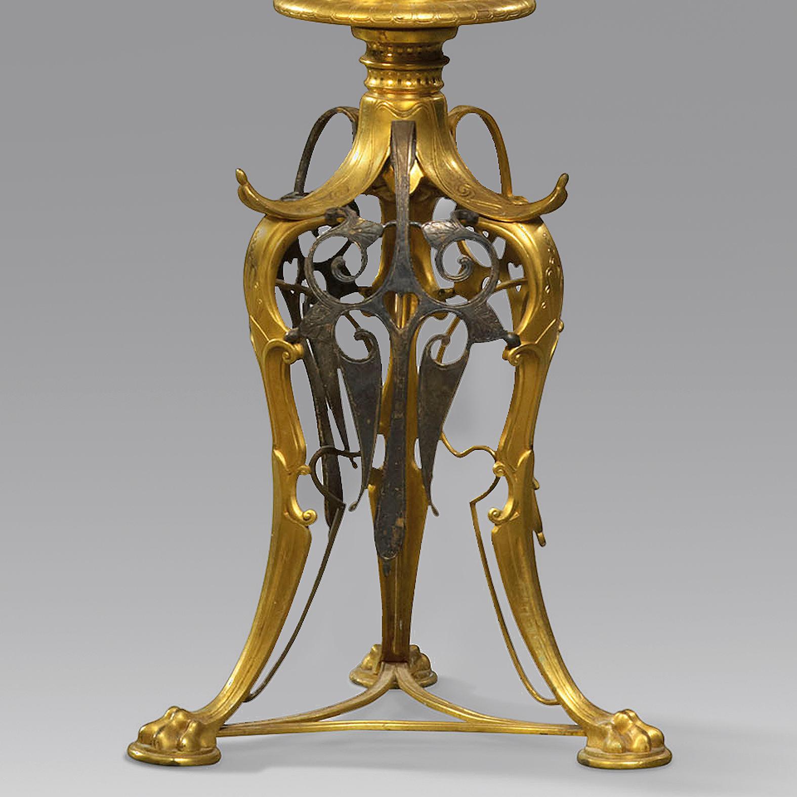 A Pair of Rare 'Neo-Grec' Gilt and Patinated Bronze Torchère Stands, Attributed to Ferdinand Barbedienne.

Each torchere has an inset marble top with suspended chains, raised on a fluted column cast with acanthus and supported by a tripod base cast