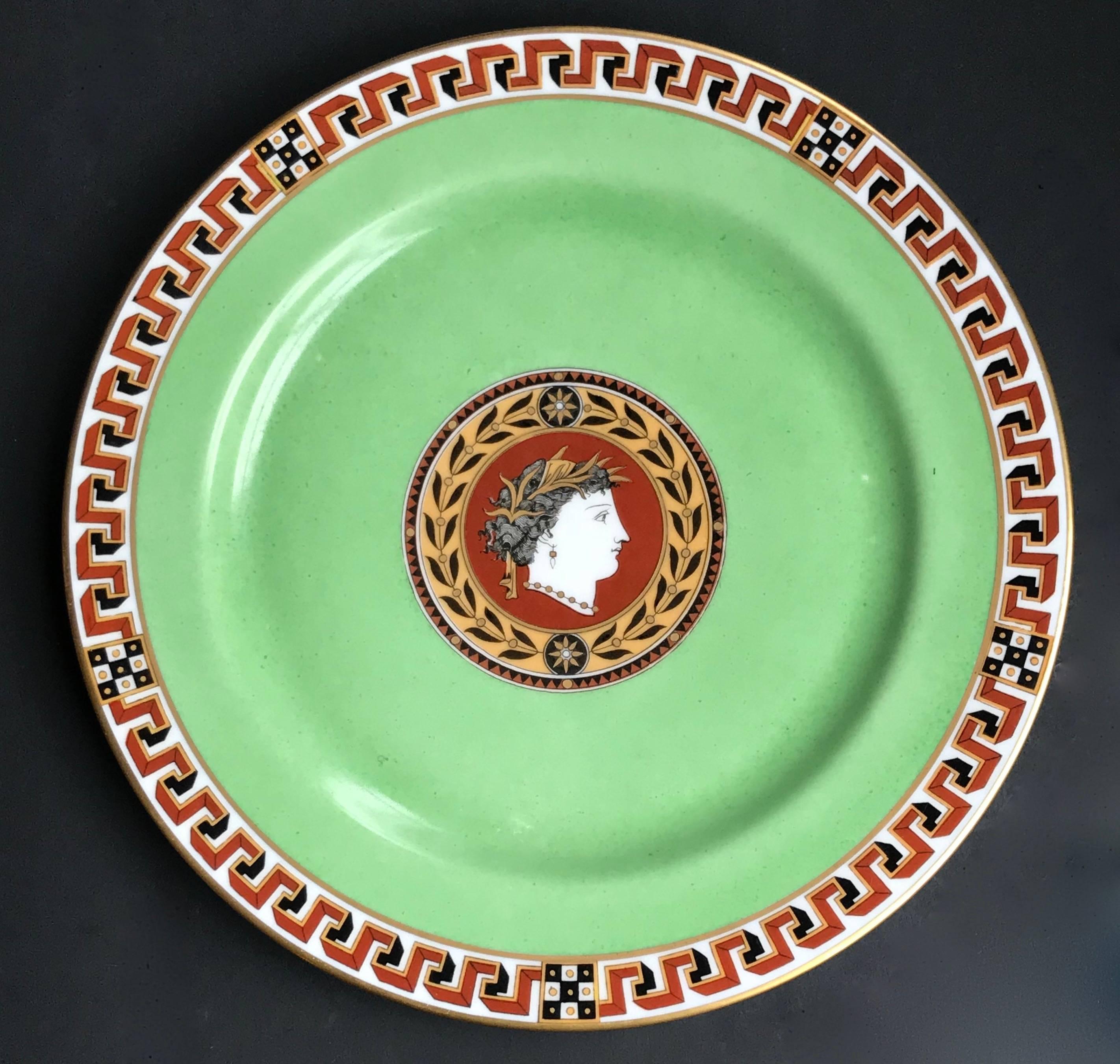 Pair of Limoges porcelain plates in the French Empire style with central medallion of a Grecian woman wearing a laurel crown in profile surmounted by laurel leaves. Greek key border and a beautiful and distinctive green ground. Gold border to edges