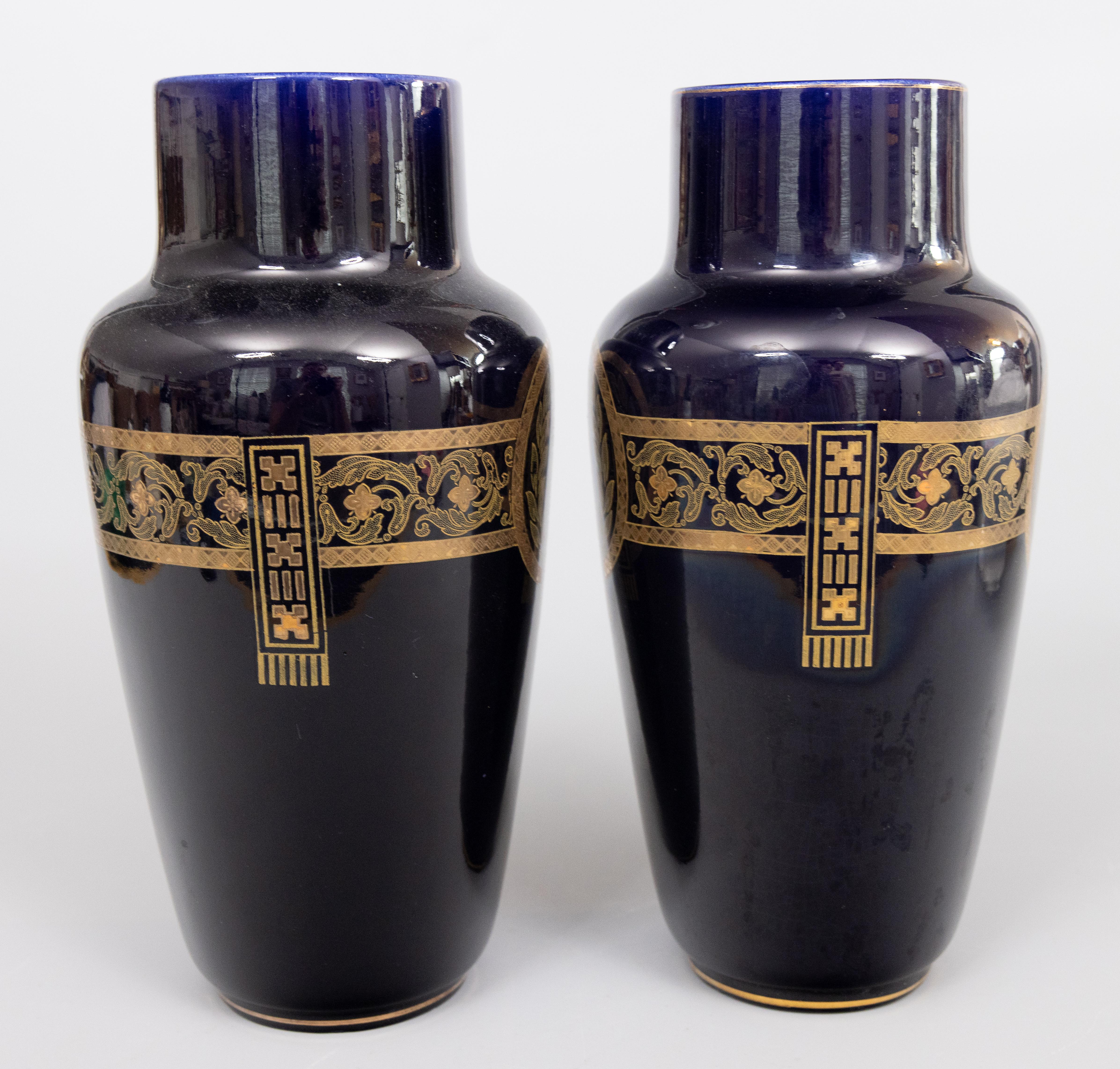 A gorgeous pair of antique Neoclassical style French Sarreguemines cobalt blue majolica vases, circa 1900. Maker's mark on reverse. These stylish chic vases are decorated with gold gilt laurel wreaths and foliate designs on a rich dark cobalt blue