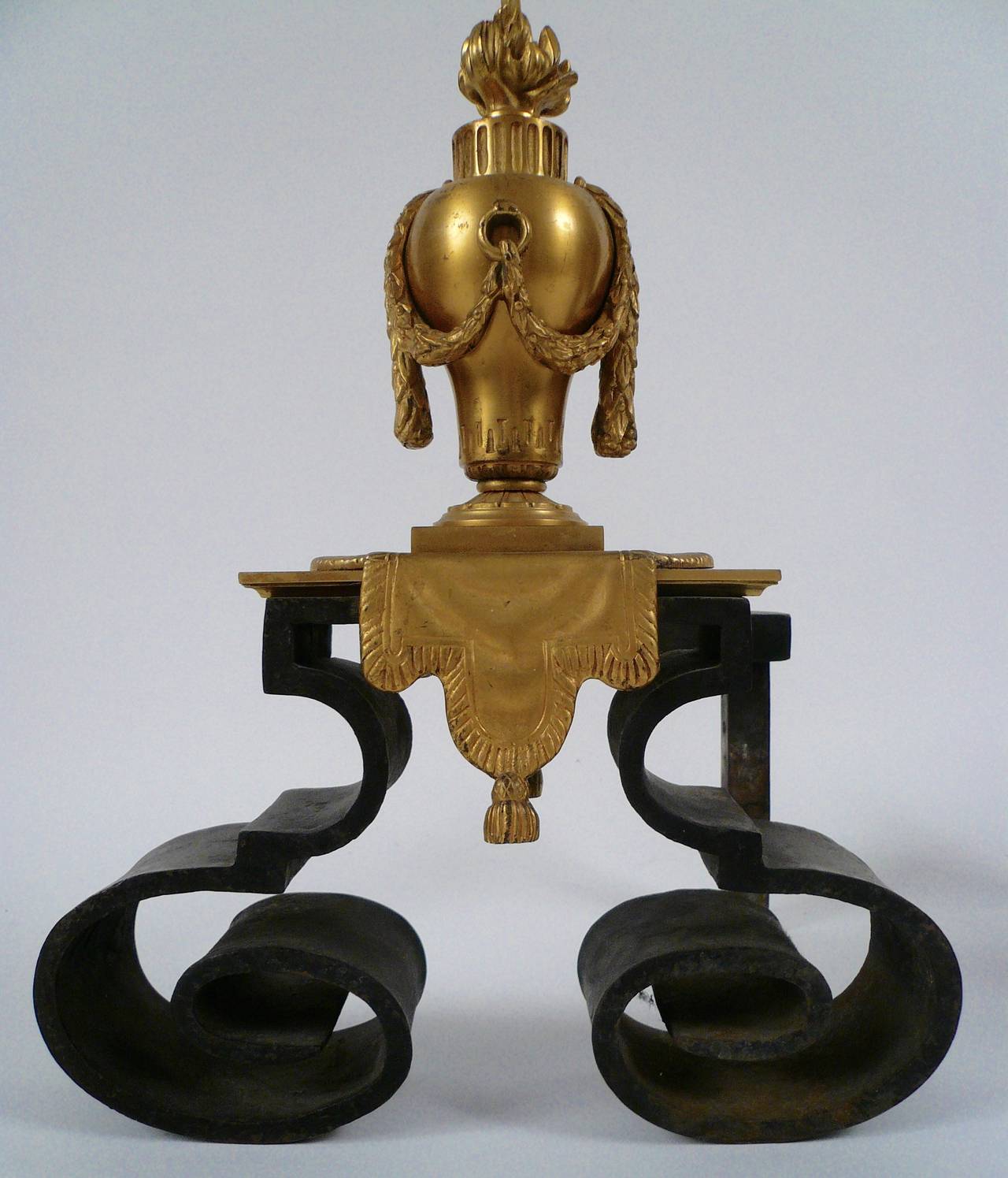 Pair of neoclassical style gilt bronze andirons, of swagged urn form, terminating in flame finials.