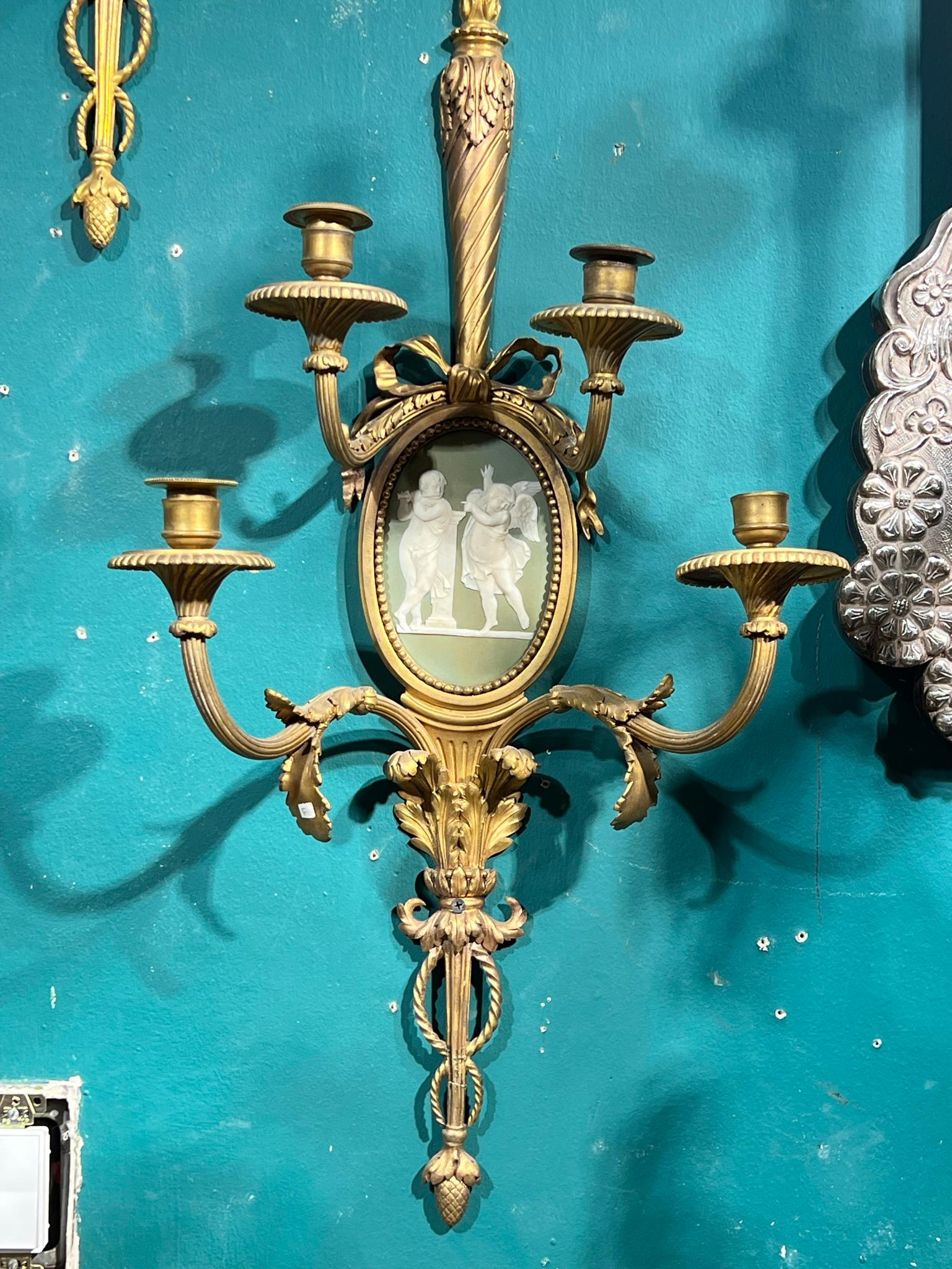 Pair of antique (19th century) neoclassical Louis XVI style gilt bronze wall lights with oval shaped white and forest green jasperware porcelain plaques depicting putti and a dancing muse, possibly from Wedgwood.