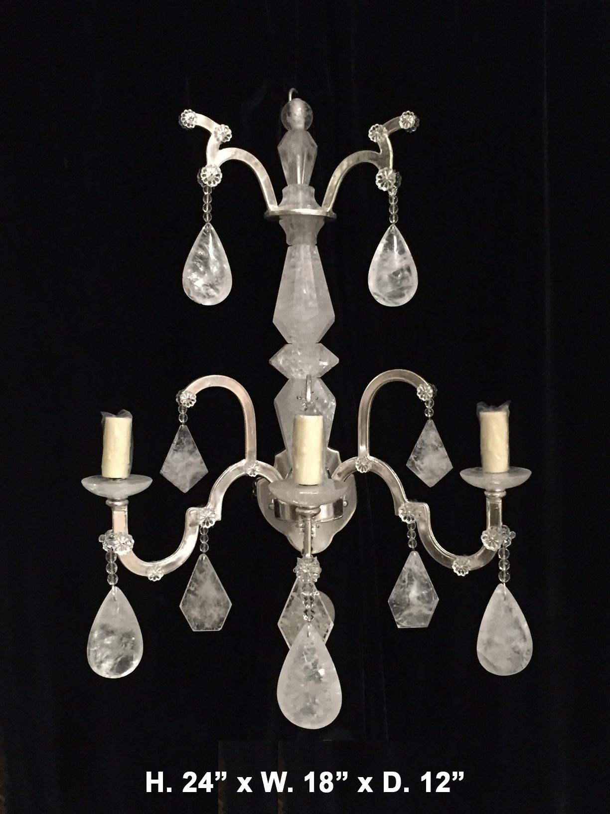 Striking pair of neoclassical style hand-carved and polished rock crystal silver-leafed three-light sconces.
21st century.
Each silver-leafed sconce is centered with a hand-carved and faceted rock crystal central shaft, issuing three scrolling