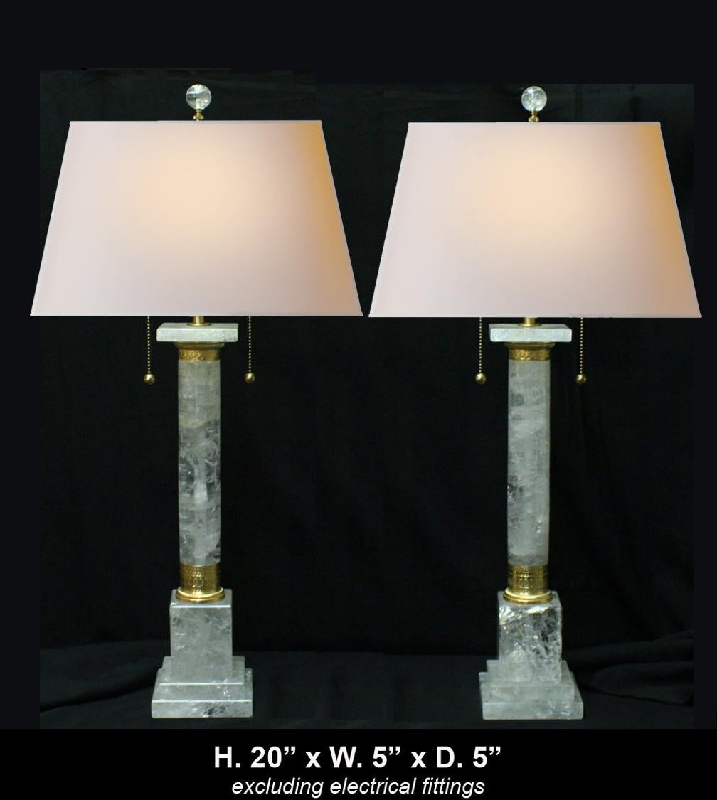 Pair of neoclassical hand carved and polished rock crystal and ormolu columnar lamps with round rock crystal finial.
The quality of rock crystal used on this pair is very good.  

Rock crystal lamp dimensions without electrical fittings:
H. 20