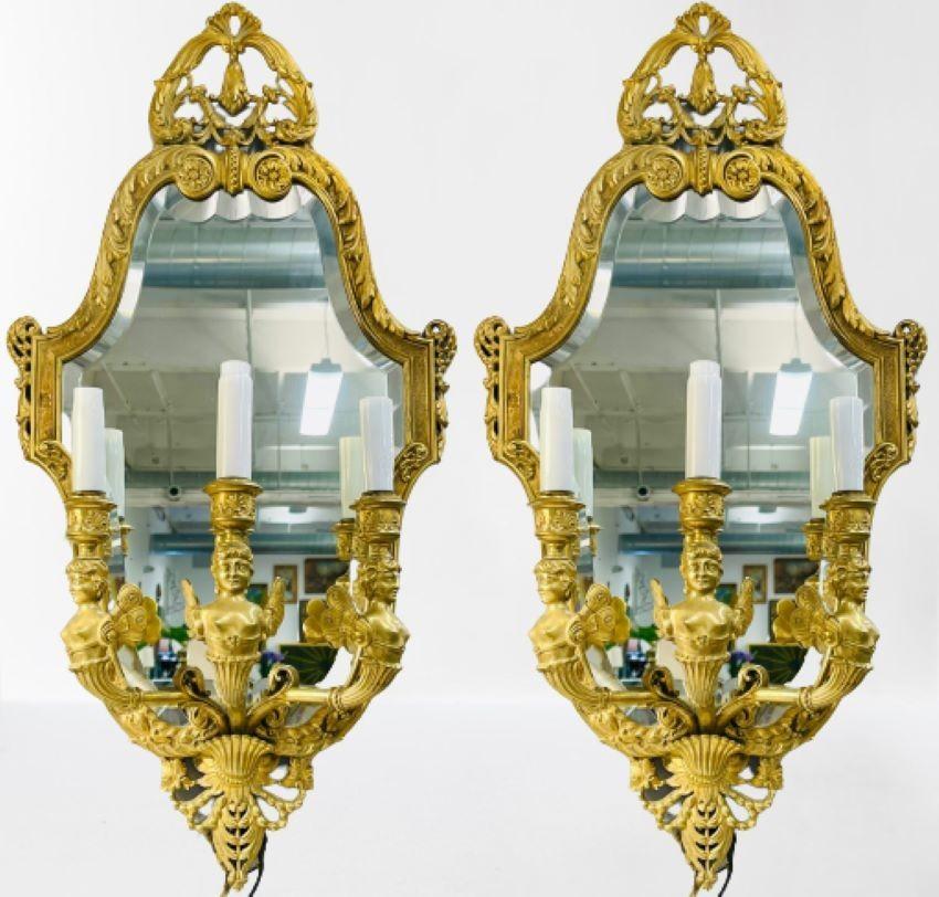 Coppia di appliques girandole in bronzo in stile neoclassico, la raffinata cornice in bronzo con retro a specchio e tre bracci decorati con figurine di donna.