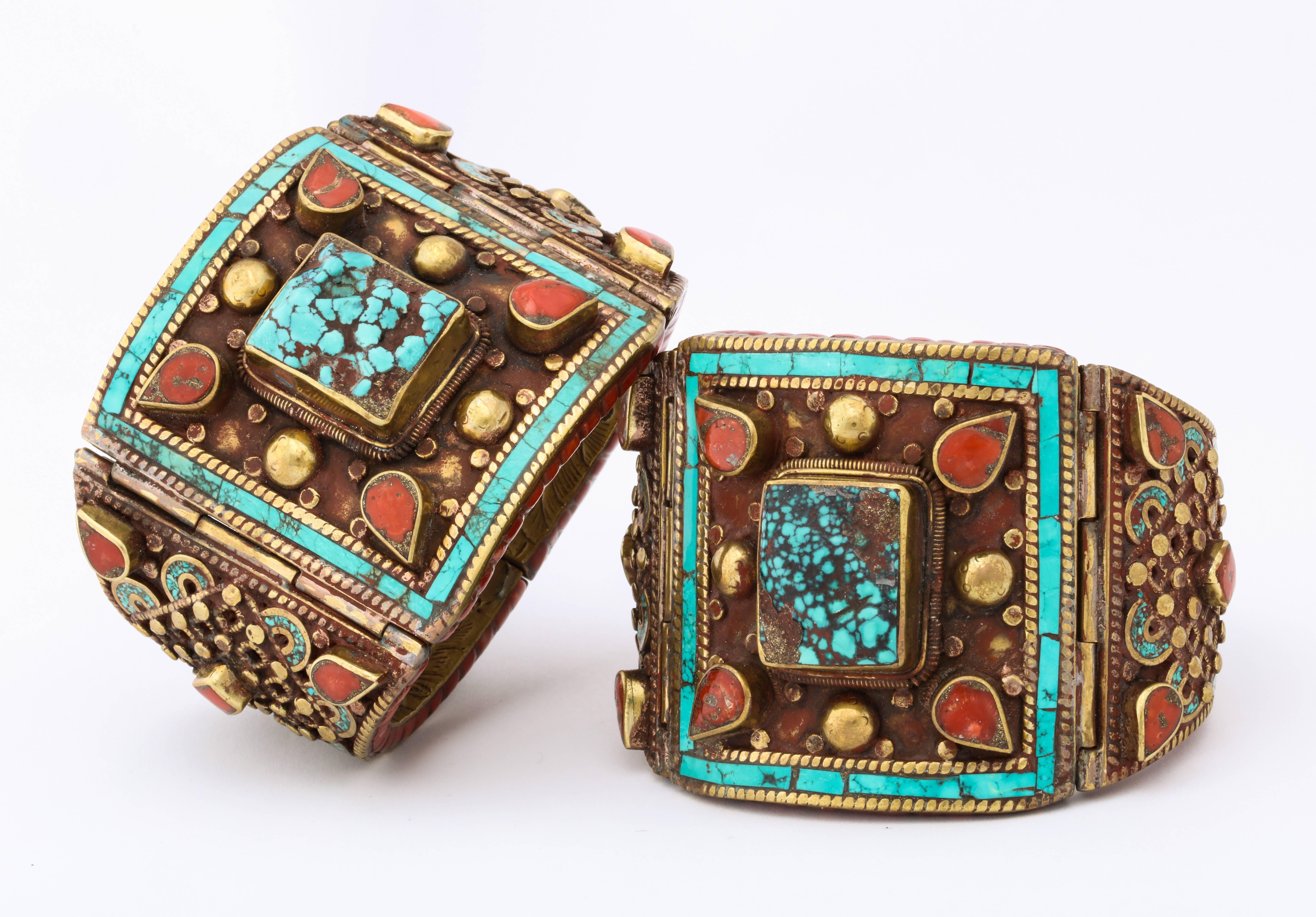 Magnificent, hand made, ornamental cuffs of inlaid turquoise, turquoise with matrix as well as coral completely cover these gold metal bracelets exhibiting no end of style and drama. There is so much to describe here. Feast your eyes on the