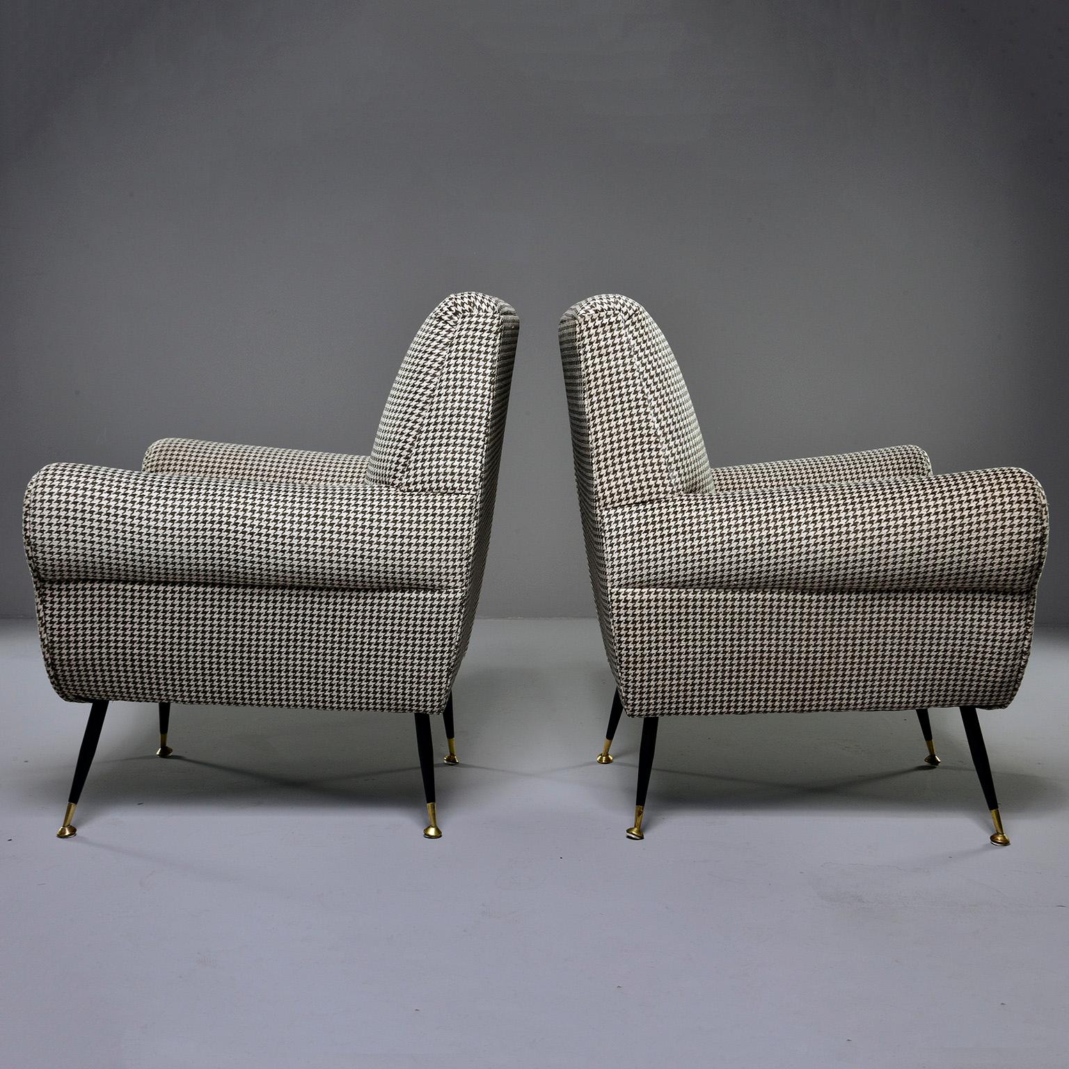 Pair of armchairs designed by Gigi Radice for Italian maker Minotti, circa late 1950s. This pair of chairs feature curvy, mid century Italian lines, narrow metal legs with black enamel finish and brass feet and new upholstery. Fabric is a short