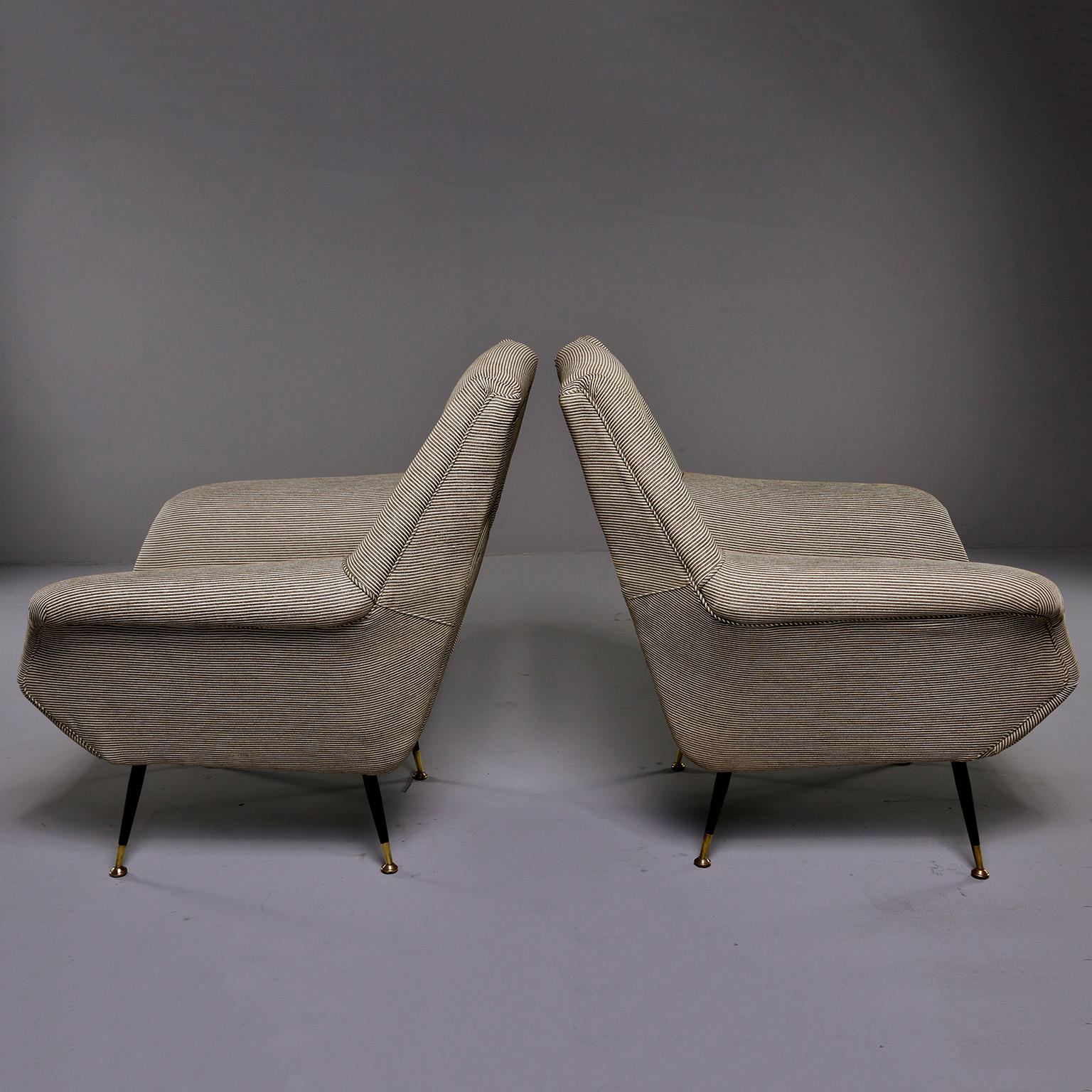 Pair of chairs designed by Gigi Radice for Minotti of Italy, circa early 1960s. Great midcentury lines with an open work tall seat back, tapered black enameled legs with brass feet and curved arms. All new upholstery, foam and webbing. Robert Allen