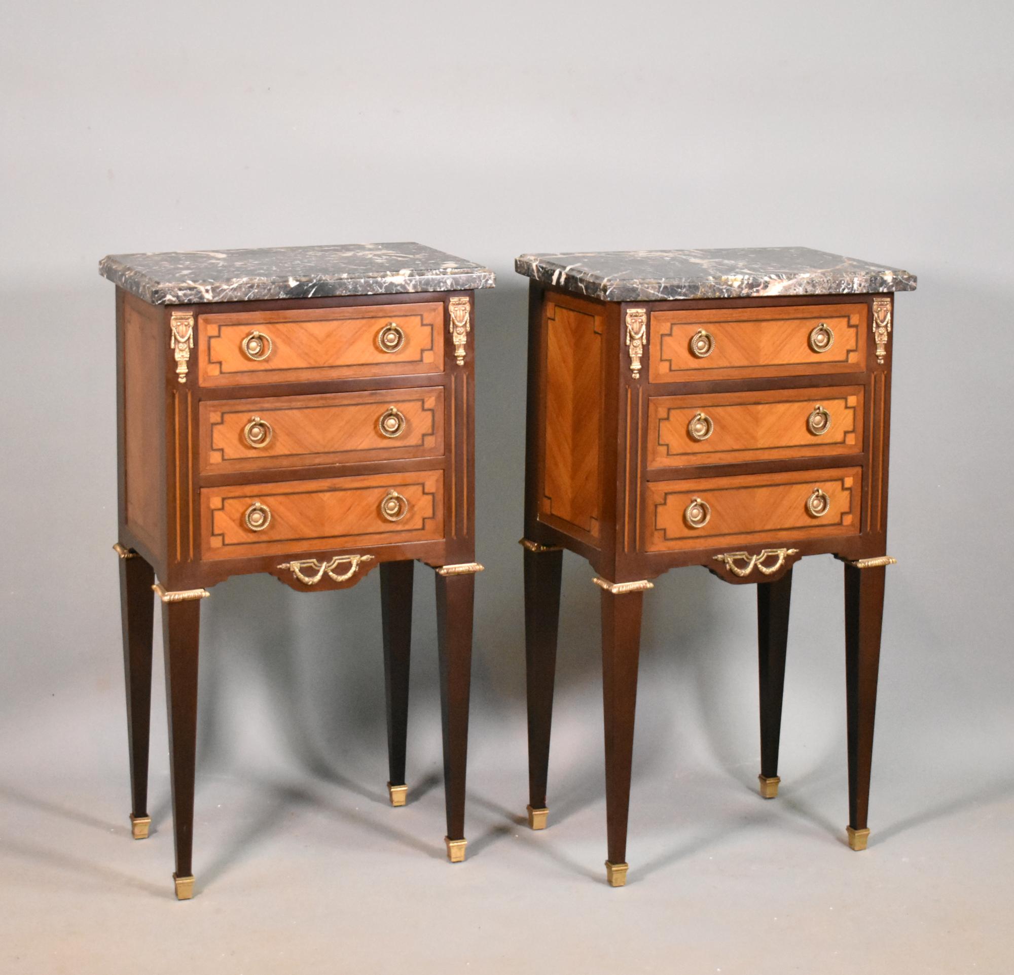 Pair Bedside Cabinets Louis XVI Directoire Style 

A striking pair of bedside cabinets in rosewood with variegated marble tops with a moulded outer edge. 

With teak frames, rosewood book-matched veneers to the drawers and sides and surrounded