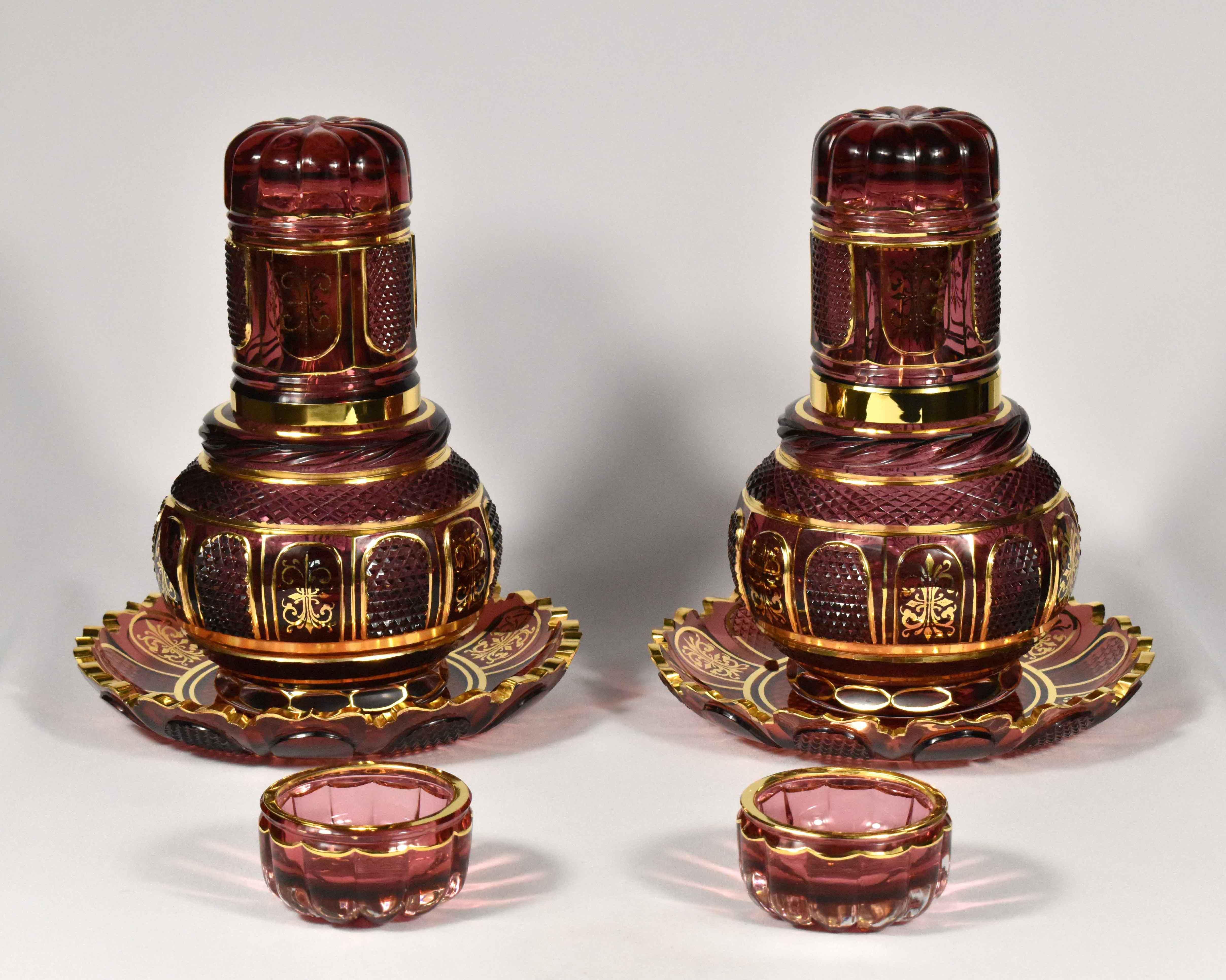 This hand-made set is meant to be placed on a nighstand to hold water. It’s made from gold ruby glass. The glass is painted by hand with gold and cut by hand. 
The whole set includes two beautiful carafes, a couple of glasses, two bowls for rings,