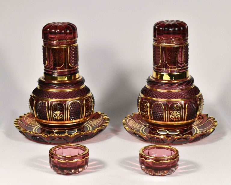 This hand-made set is meant to be placed on a nighstand to hold water. It’s made from gold ruby glass. The glass is painted by hand with gold and cut by hand. 
The whole set includes two beautiful carafes, a couple of glasses, two bowls for rings,