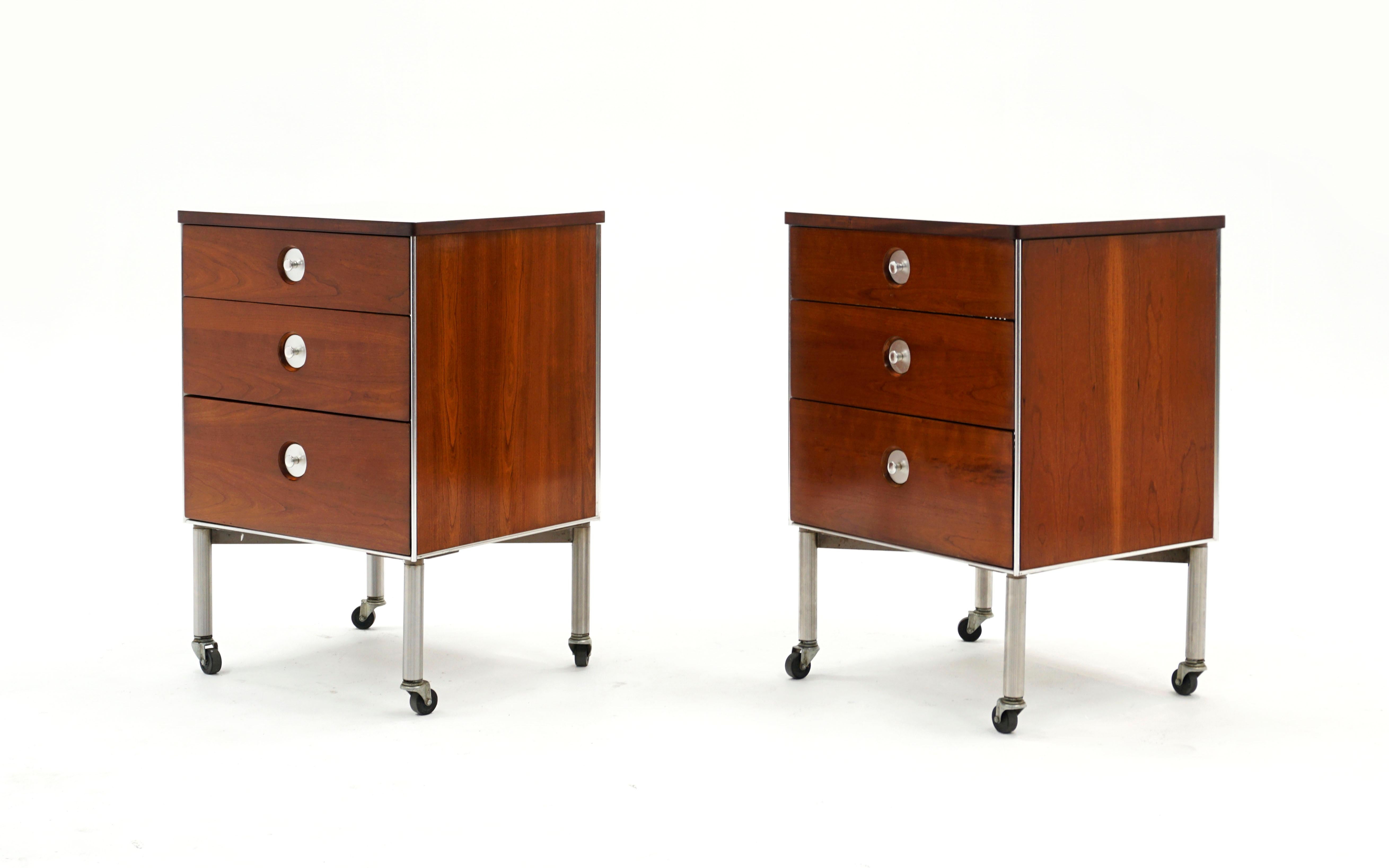 Pair of night stands / side tables designed by Raymond Loewy and manufactured by Hill Rom. Walnut with lightly patterned off white laminate tops and aluminum pulls and trip. Three drawers. Both on the original casters. Very good condition and ready