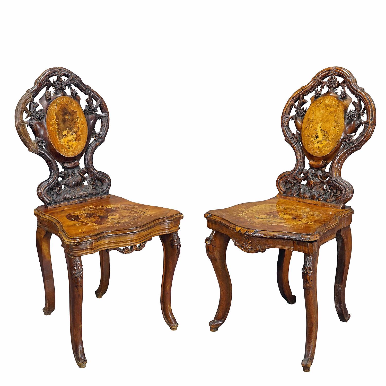 Coppia di sedie intarsiate Edelweis in legno di noce Svizzera Brienz 1900

Una coppia di splendide sedie in legno di noce intarsiato, decorate con scenari intarsiati e dipinti raffiguranti camosci, capre, lepri, cacciatori, cervi e fiori di