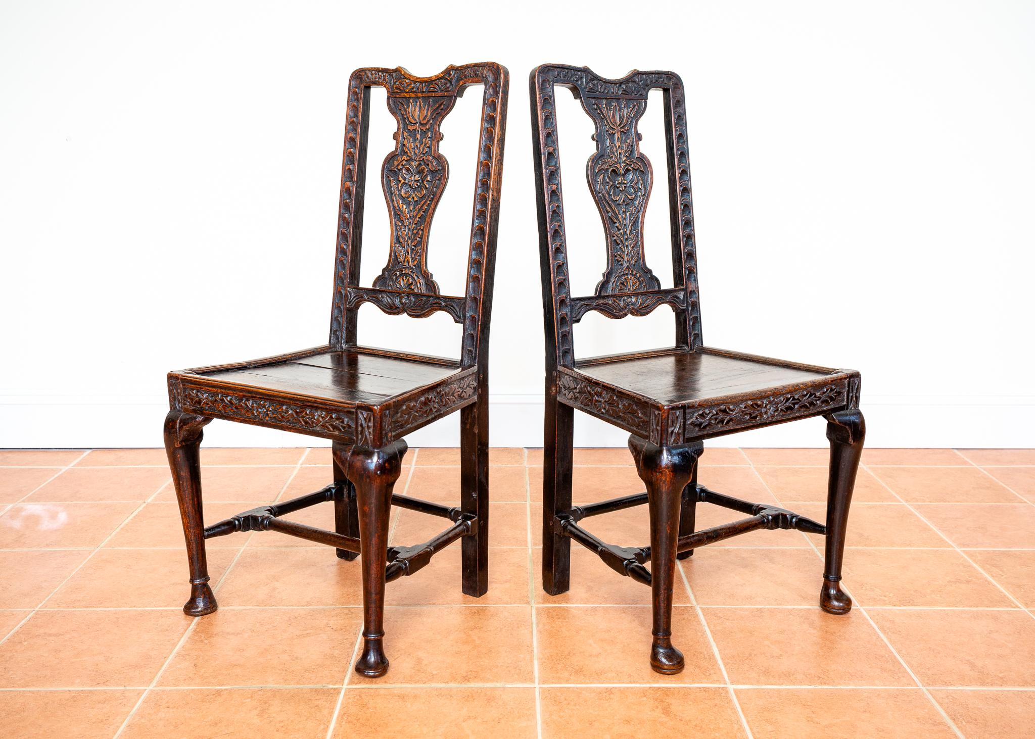 A remarkable and museum-worthy pair of extremely rare and attractive Jacobean carved oak chairs in lovely antique condition. Most likely made in England in the late-Jacobean period around 1620, this delightful and versatile pair make great hallway,