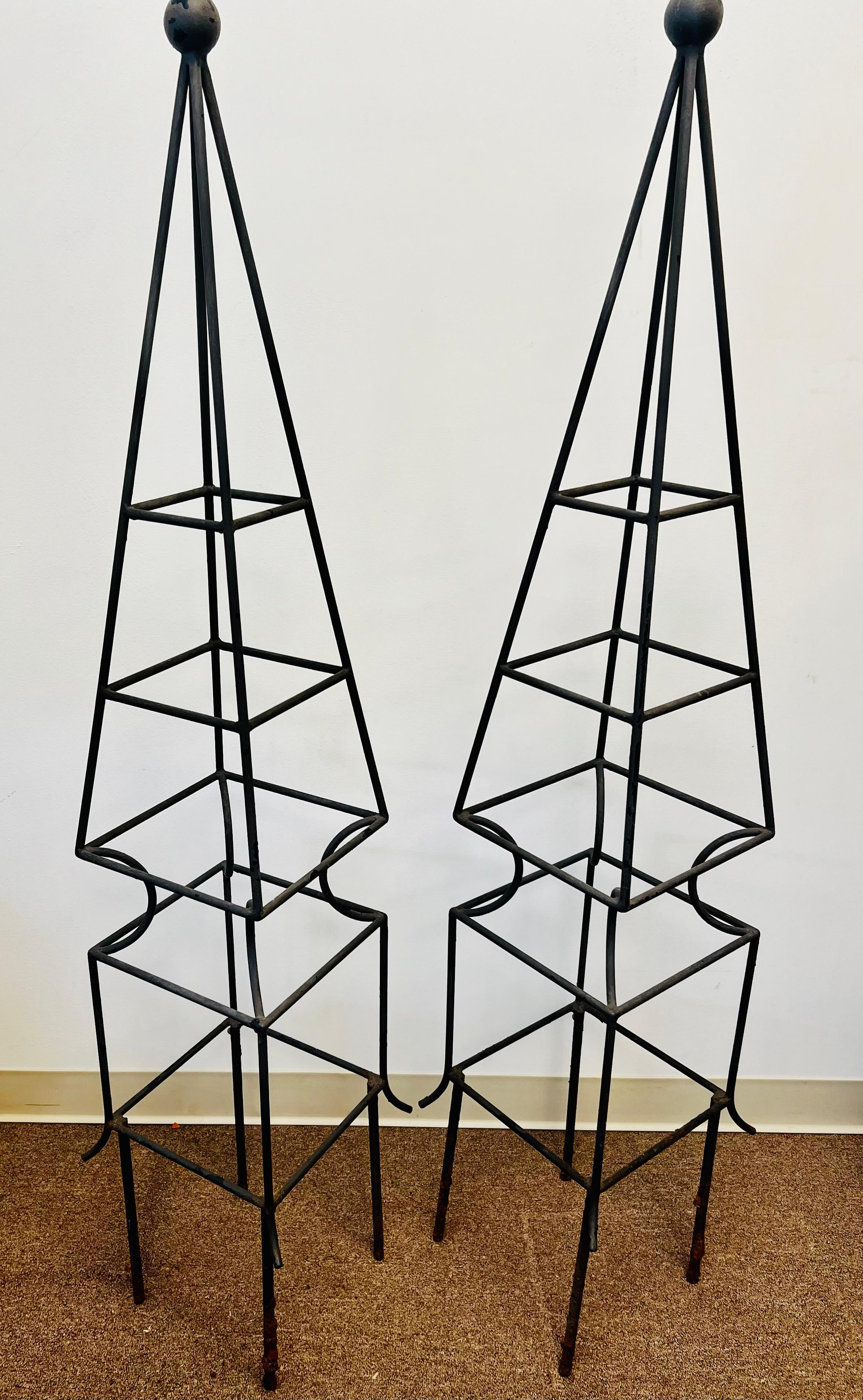 A pair of hand crafted wrought iron topiary forms that are perfect for growing flowering vines or vegetables.  These neoclassical forms would look handsome on their own in a garden.  I had them in Louis XVI orangery containers with purple and white
