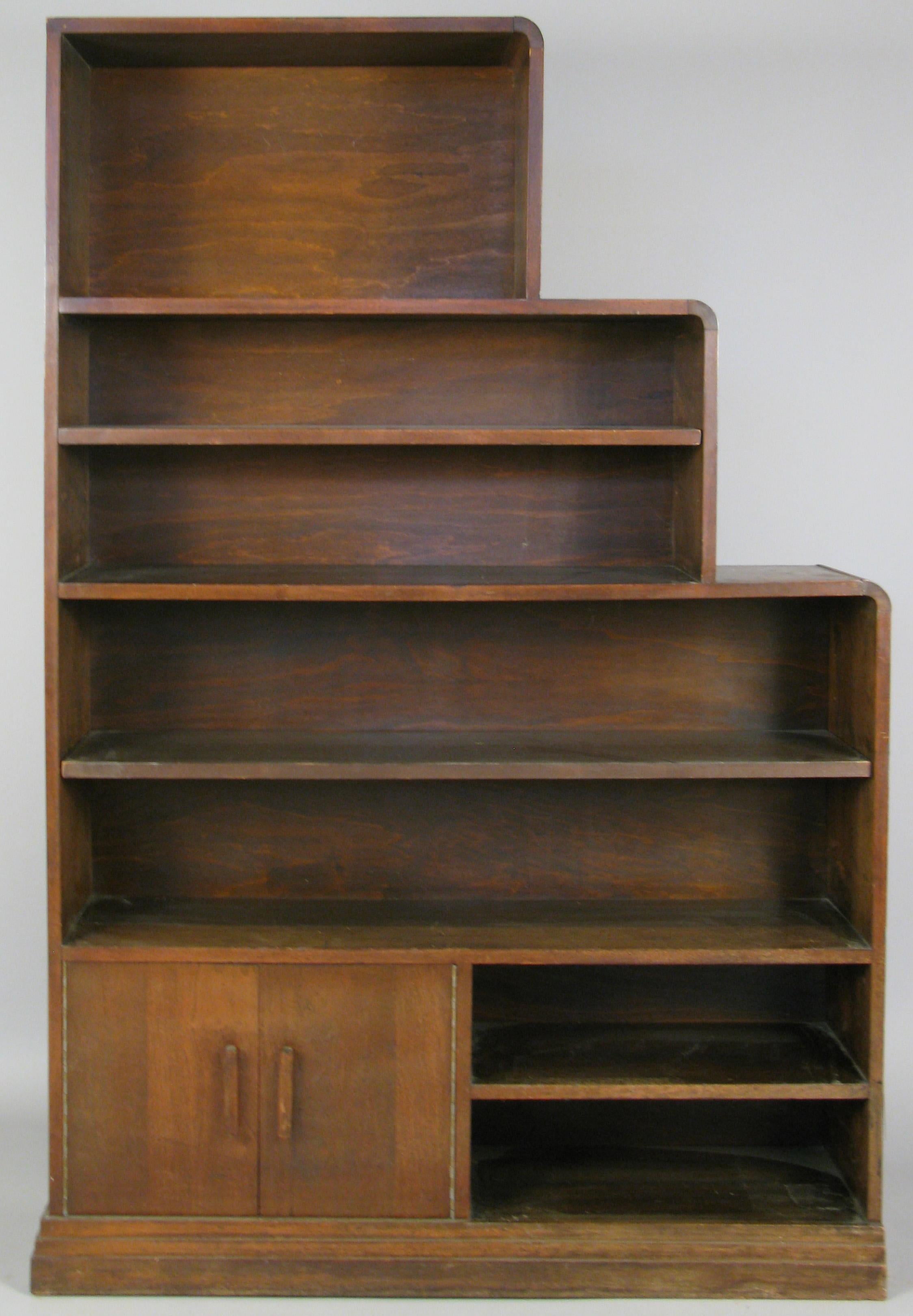 a very handsome pair of 1940s walnut bookcases in a skyscraper form, with adjustable shelves in two of the sections in each bookcase. the pair are designed as mirror images, so that if placed side by side they make a complete skyscraper form.