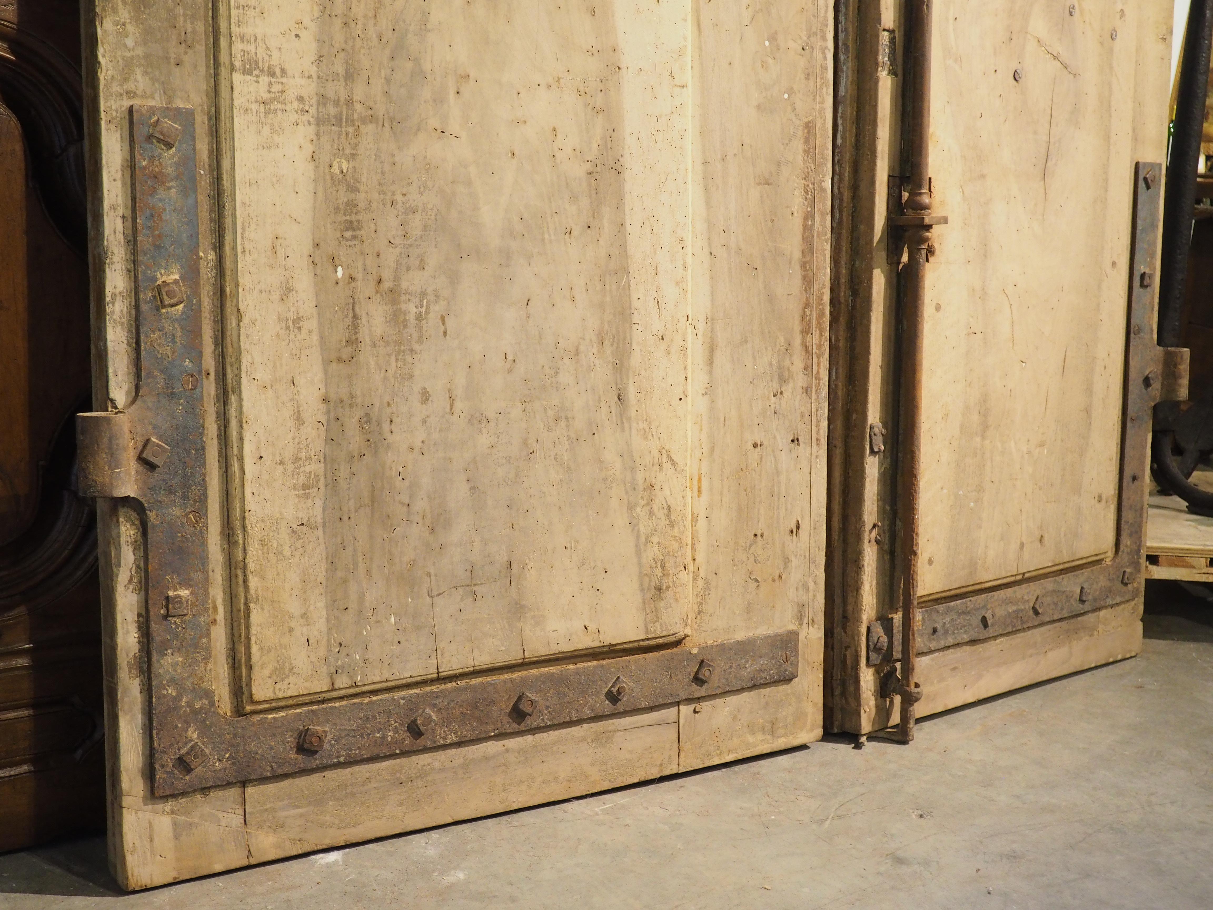 A magnificent example of French architecture, measuring nine and one-quarter feet tall, this pair of entry doors was hand-carved from walnut in the late 1600s. The doors were recently purchased from a grand wine property outside of Avignon where