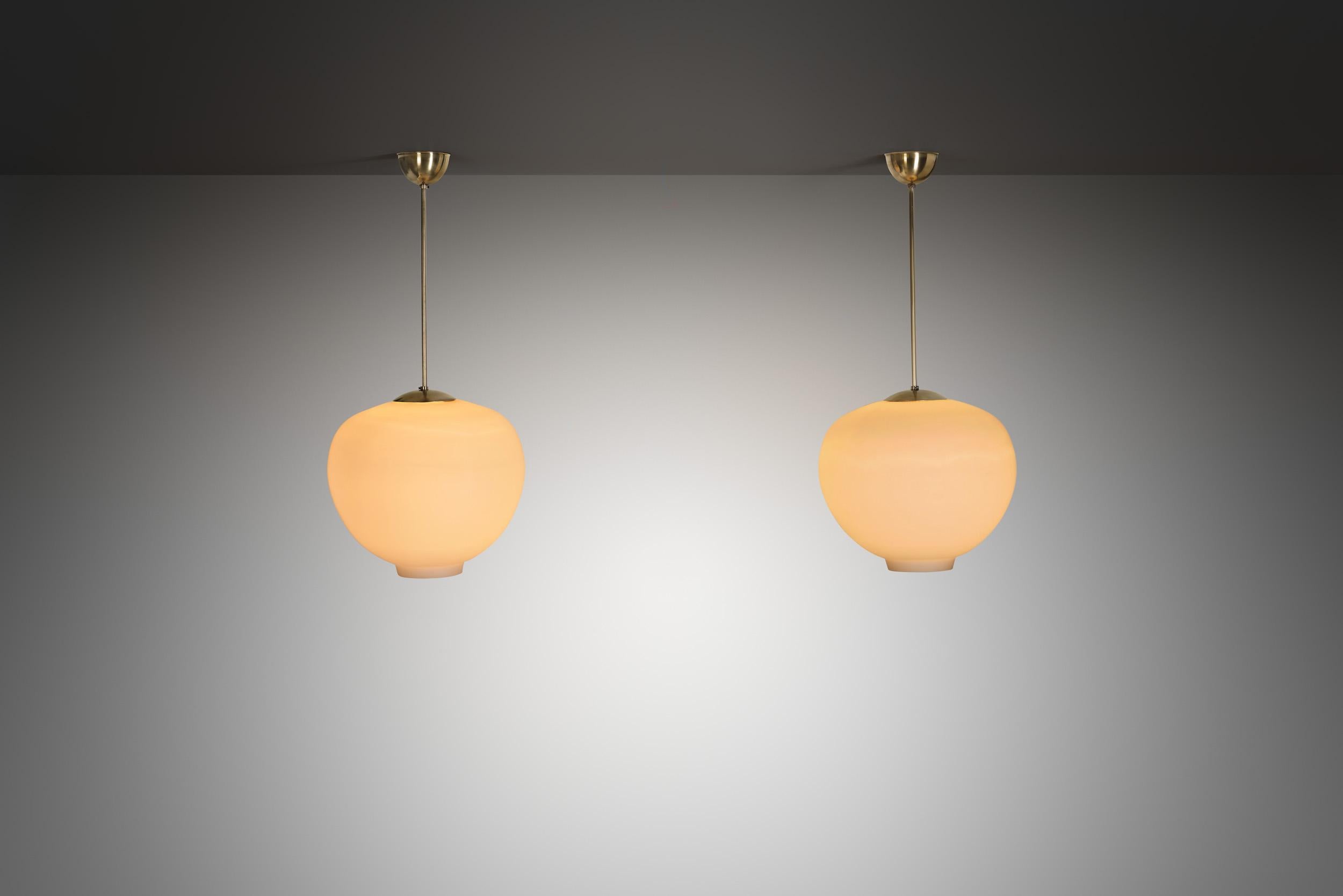 Questa coppia di lampade a sospensione progettate per Arvid Böhlmarks Lampfabrik negli anni '50, esemplifica l'eleganza e la chiarezza del design svedese di metà secolo. Böhlmarks, uno dei più rinomati produttori di illuminazione svedesi, era famoso