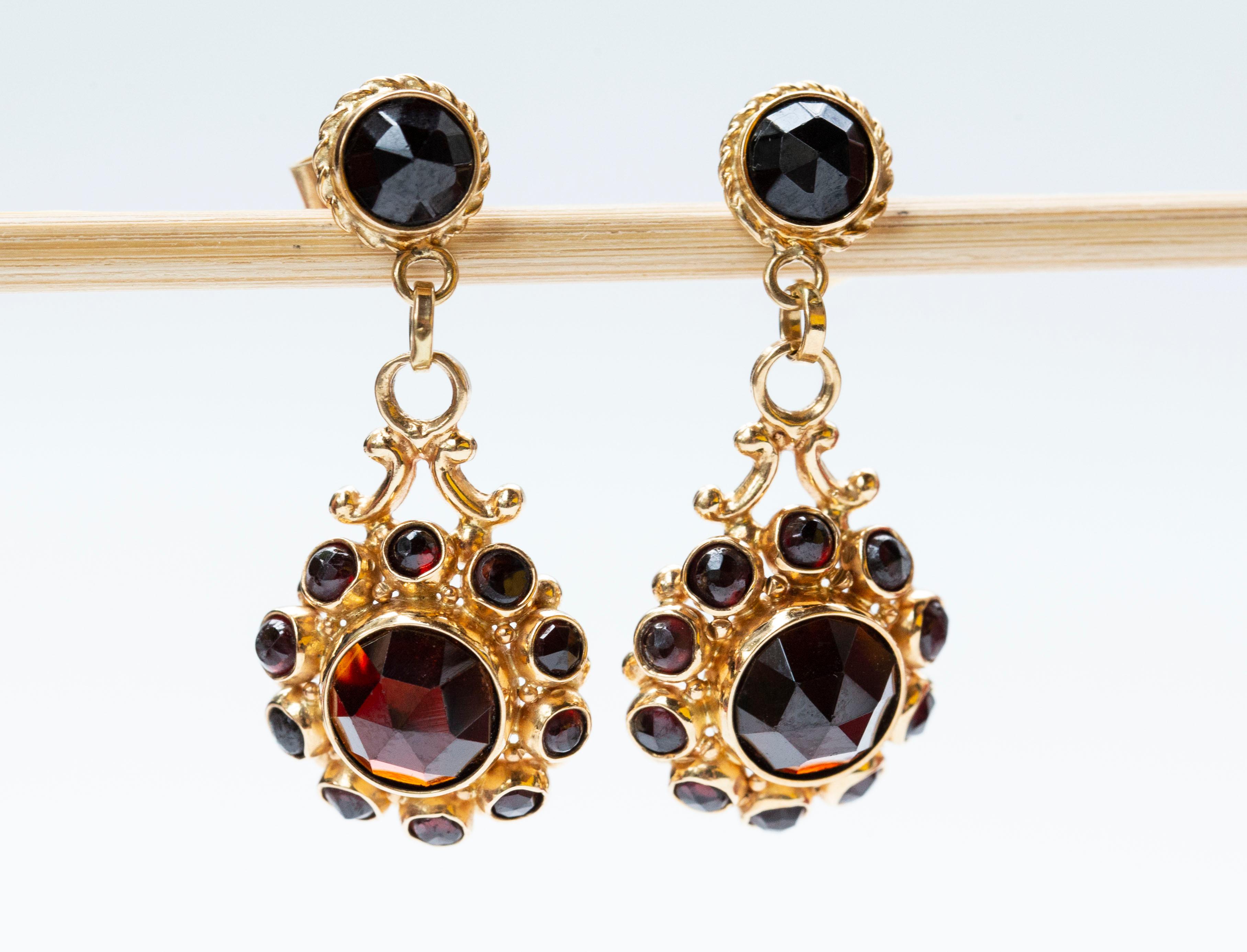 Un paio di orecchini pendenti vintage (1960 ca.) in 14 carati con una serie di granati naturali sfaccettati. Gli orecchini sono in stile vittoriano e sono molto ben fatti e di alta qualità. I granati superiori sono di taglio rotondo e sfaccettati.