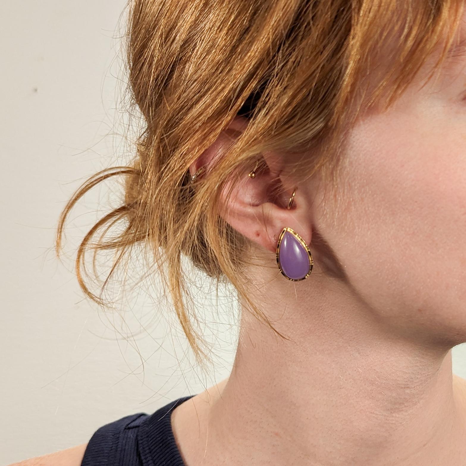 A fine pair of gold & jade earrings.

In 14k yellow gold.

Bezel-set with teardrop shaped purple lavender jade cabochons (likely enhanced).

Set with omega clips for additional security.

Simply wonderful jade earrings!

Date:
Late 20th