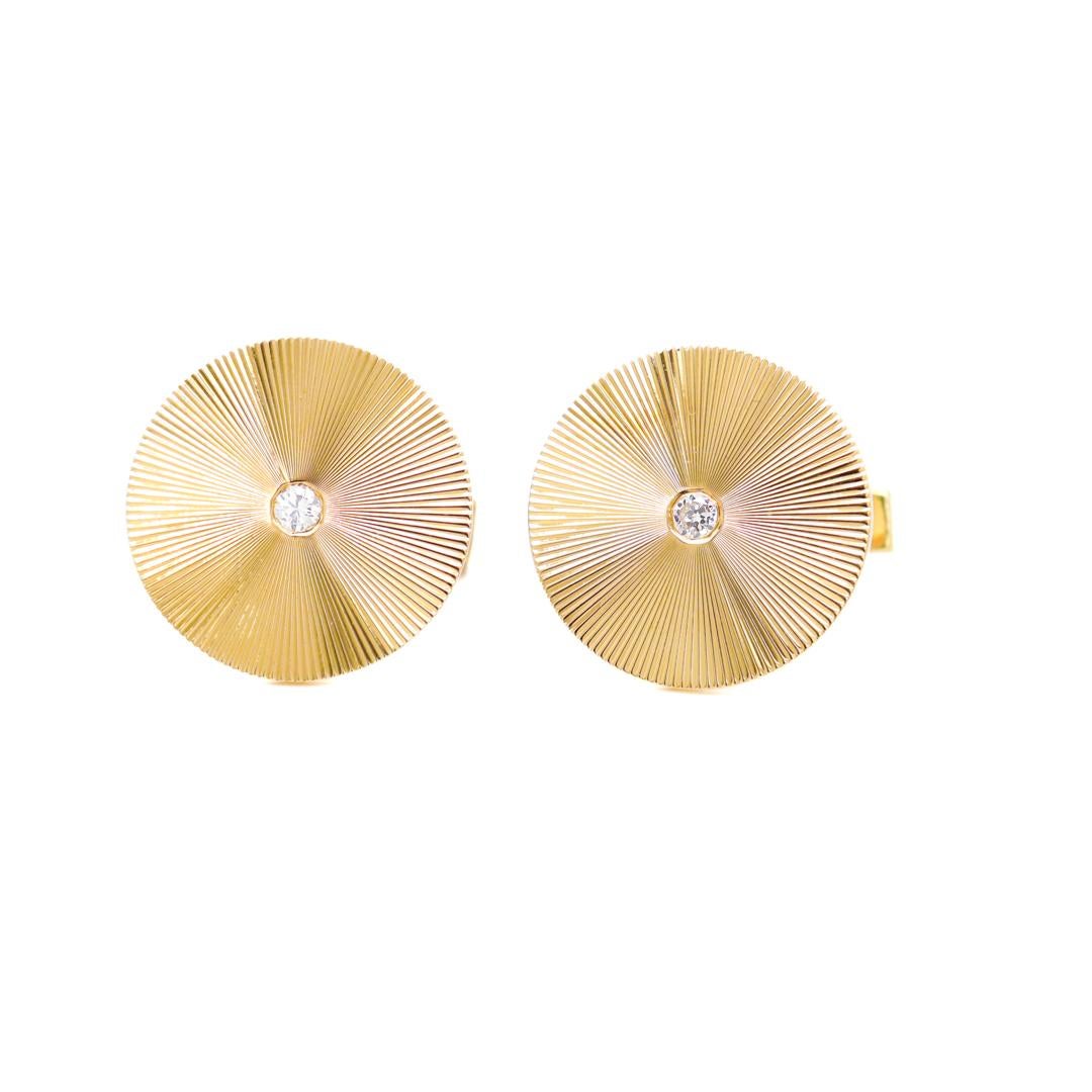 A fine pair of gold & diamond cufflinks.

By Tiffany & Co.

In 14 karat yellow gold.

Each with a round head and engraved with an starburst pattern centered on a round single cut white diamond.

The engraving catches and reflects light in a
