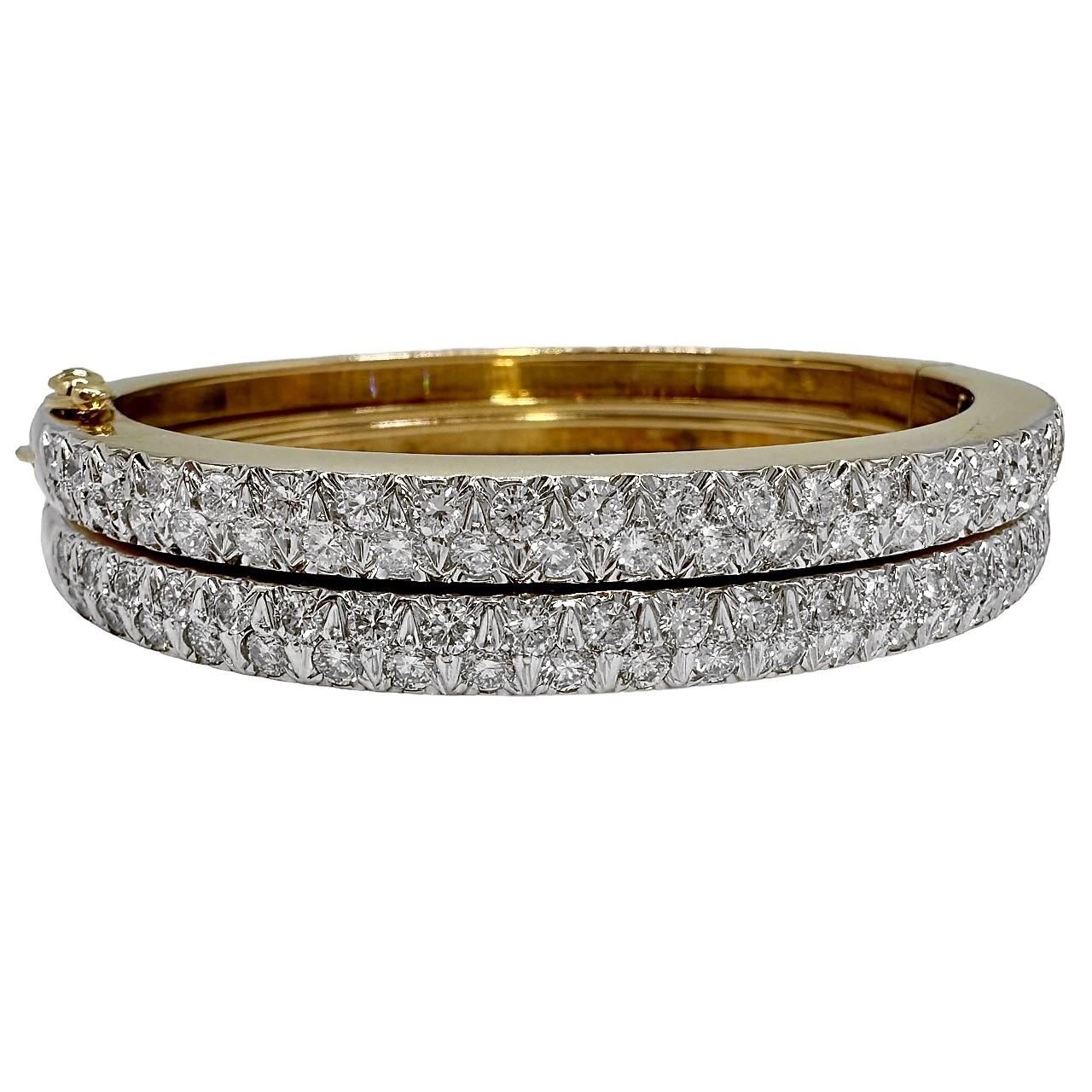 A matched pair of oval shaped, 14K Yellow Gold bangles, set on top with 88 round brilliant cut diamonds, weighing an approximate total of 5CT of G Color and VS1 Clarity.  The oval shape contours to the wrist, so that the diamonds will always be