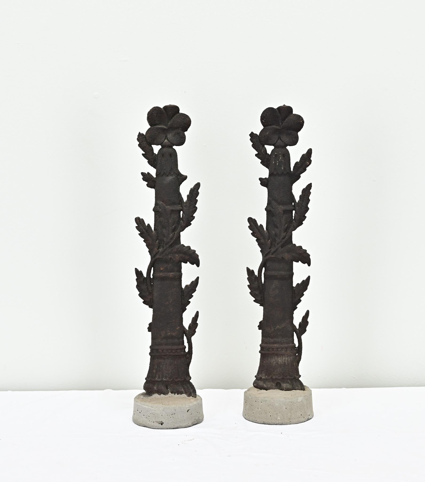 A rare pair of French cast iron fence post fragments dating back to the 1300’s. A long sprouting flower is wrapped around the flat column post, recently set in concrete bases. Sold as a set only. Be sure to view the detailed images to see the