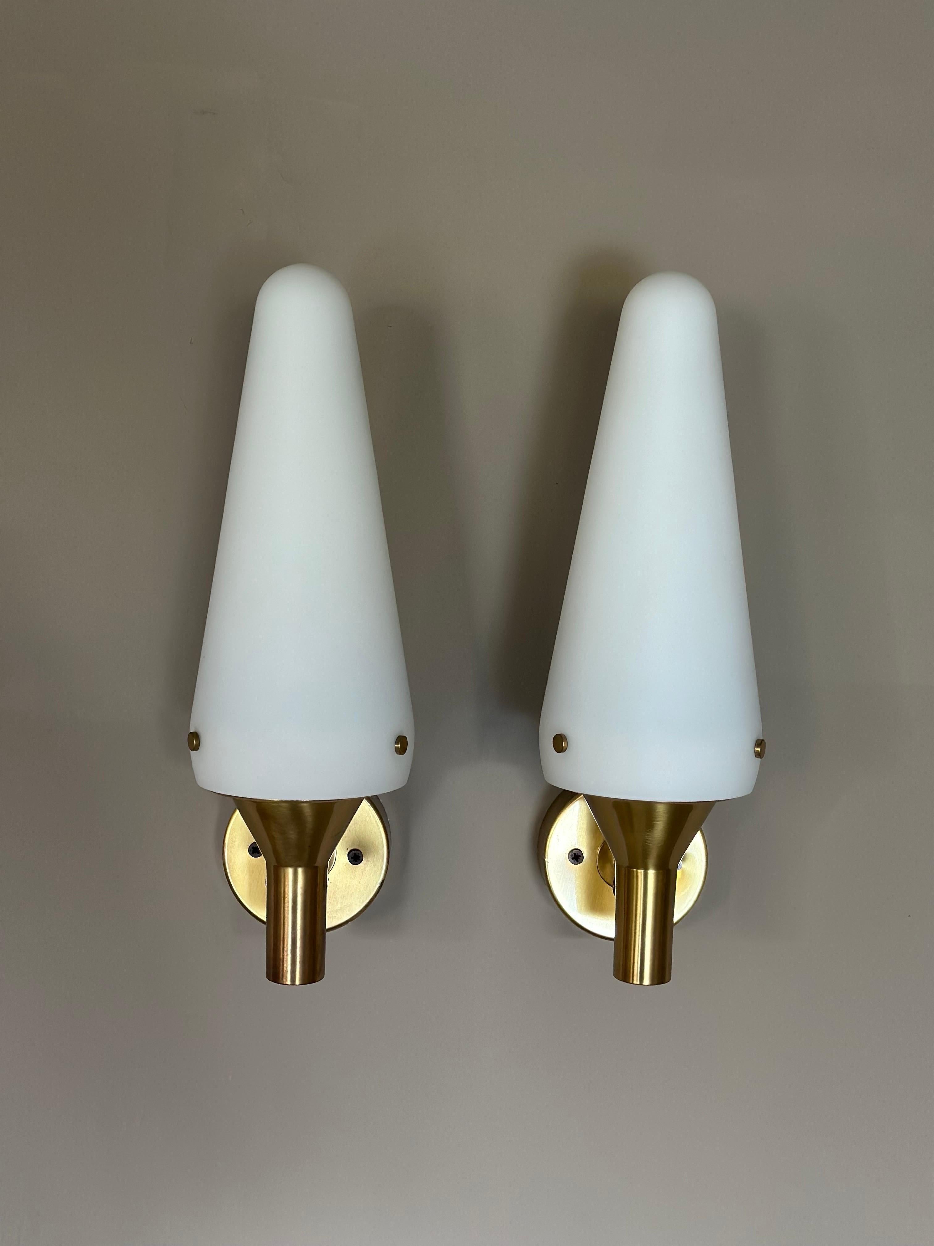 Authentic 1670 Hans-Agne Jakobsson Wall Lamps - Exquisite Brass and Opaline Glass Pair (1950s)

Introducing a remarkable pair of 1670 Hans-Agne Jakobsson Wall Lamps, meticulously crafted in the charming town of Markaryd, Sweden during the vibrant