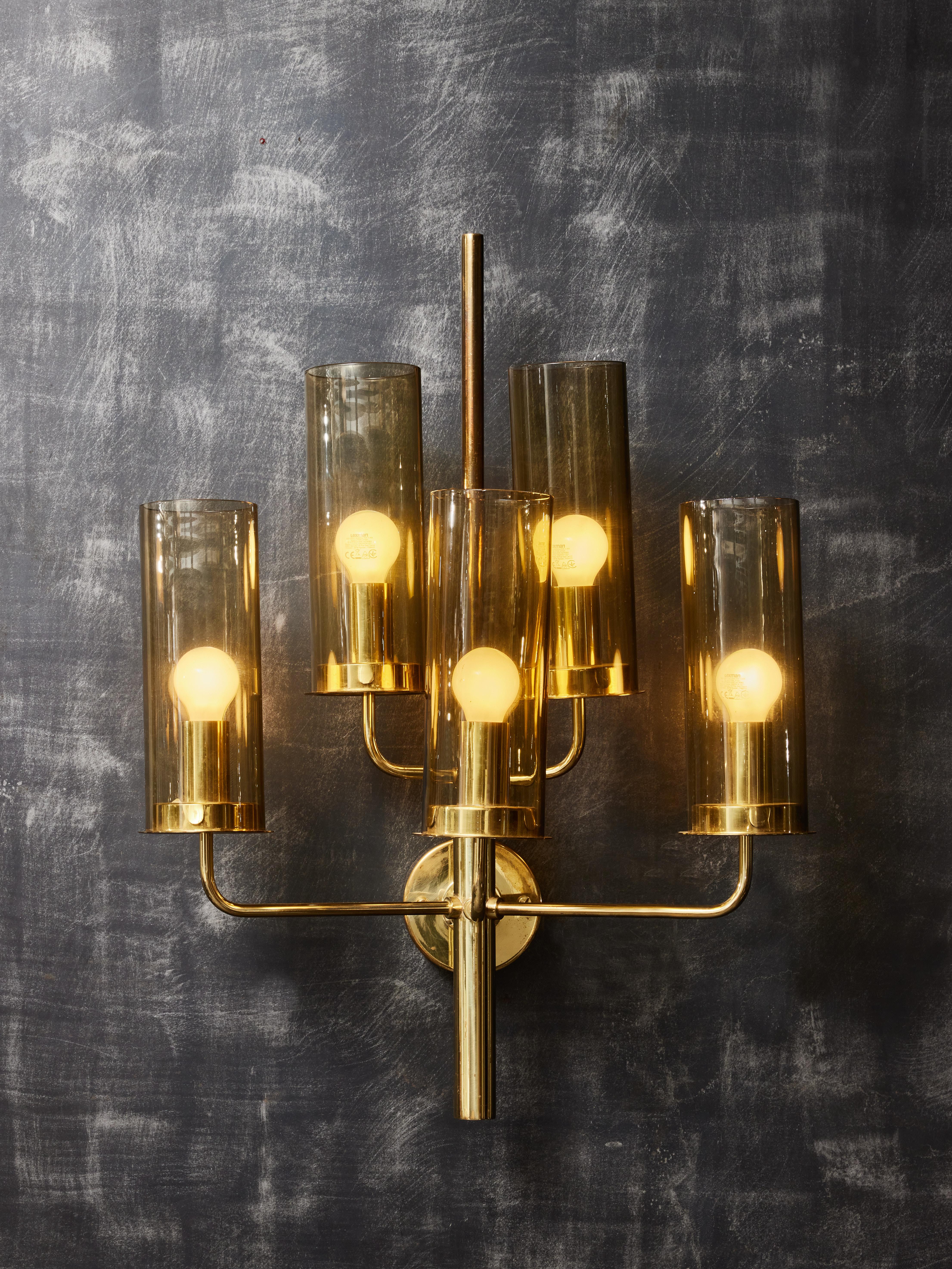 Pair of brass wall sconces by the Swedish designer Hans Agne Jakobsson, made of five arms of light with smoked glass diffuser. Original manufacturer sticker on the back.

Hans-Agne Jakobsson (1919-2009)
Born in the island of Gotland, Sweden,