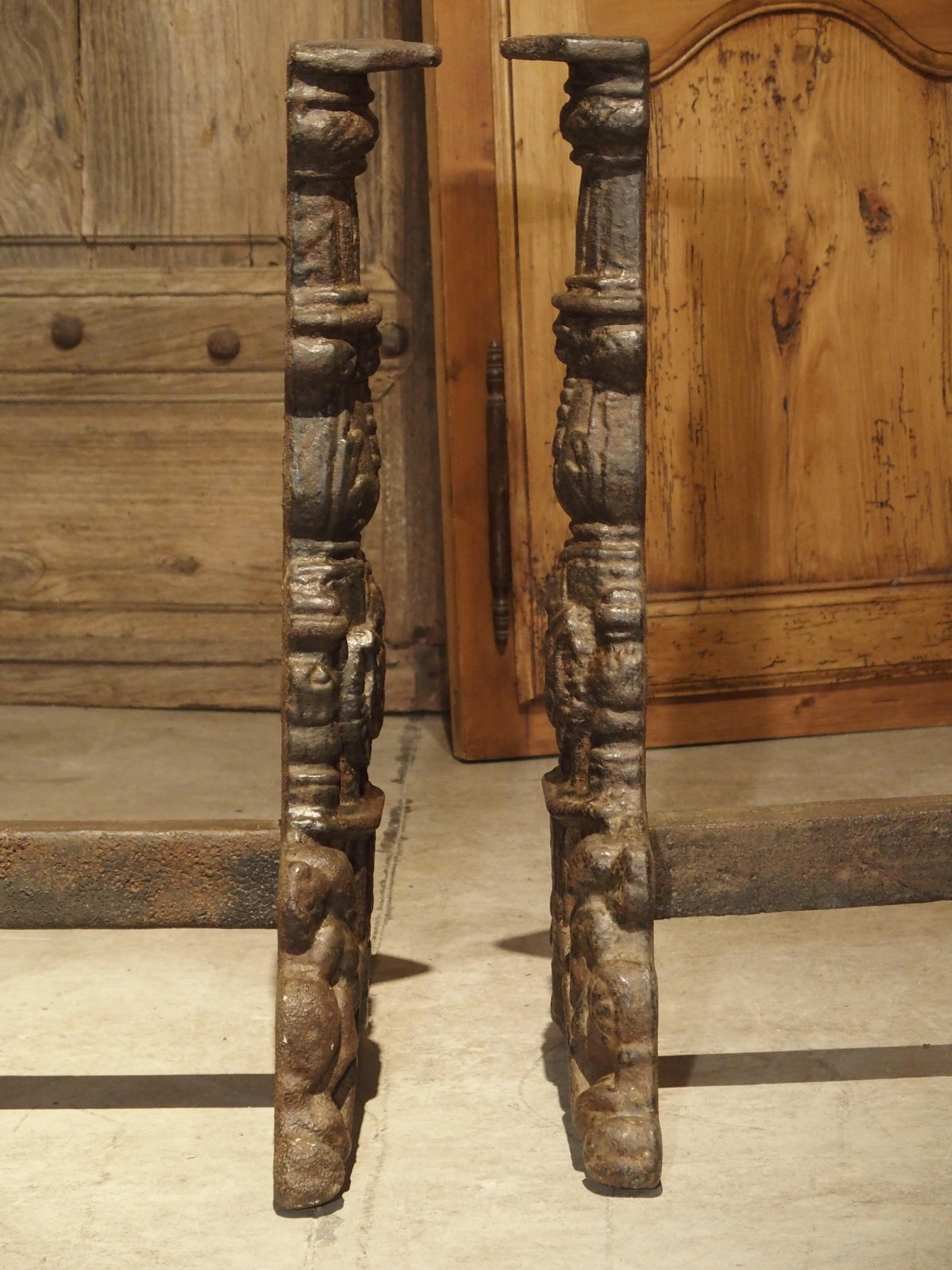 These magnificent andirons are period French Renaissance, and they date to the 1500s. There are fluted columns with balusters and a shield with a crown beneath. Pairs of winged angels rest upon the curved feet and appear to be holding up the entire