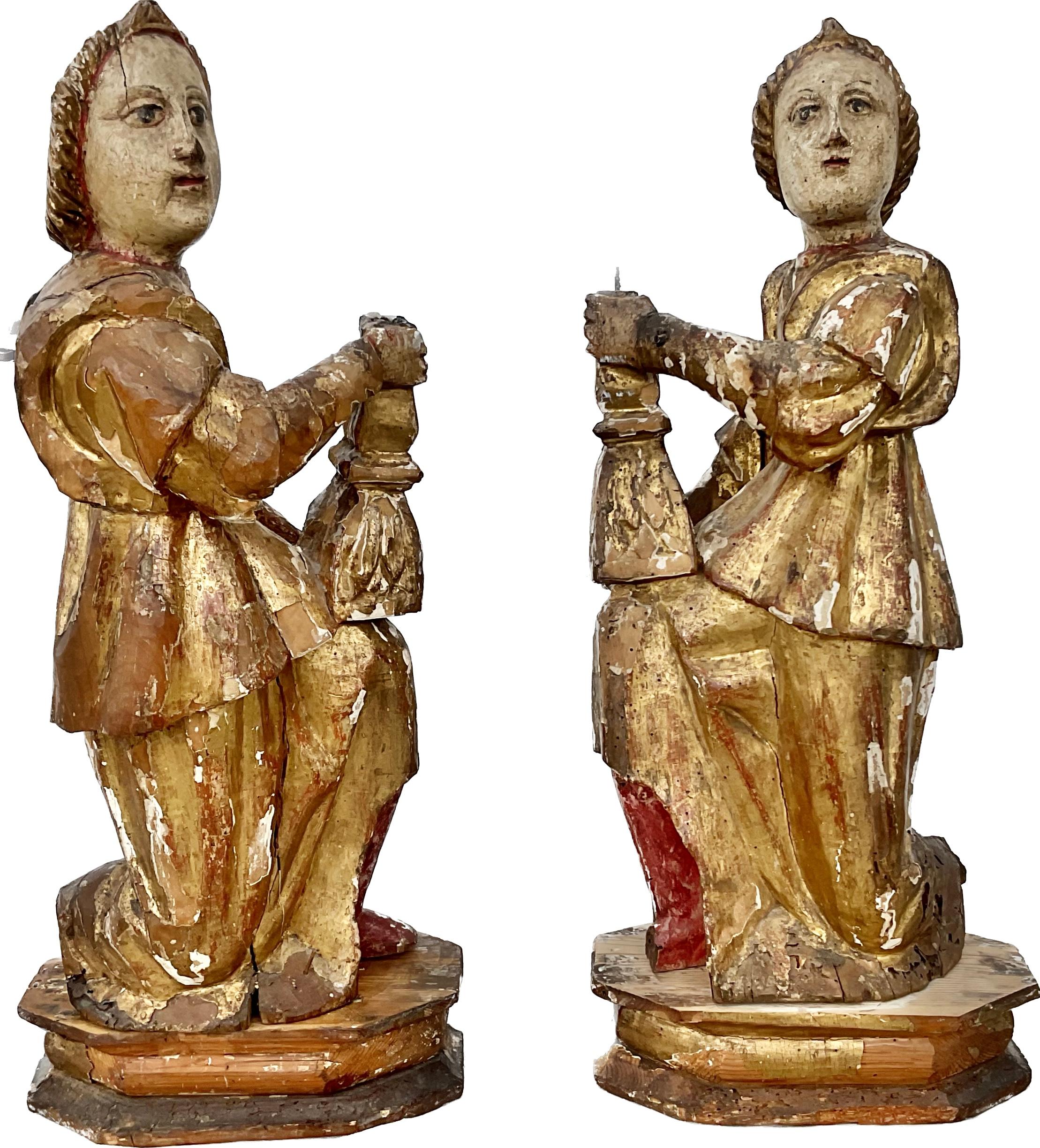 Stunning and rare pair of 16th century Italian candle bearing Angel candlesticks depicting male and a female figures from the renaissance period. Each figure is meticulously carved from wood and adorned with opulent gold gilding and polychrome