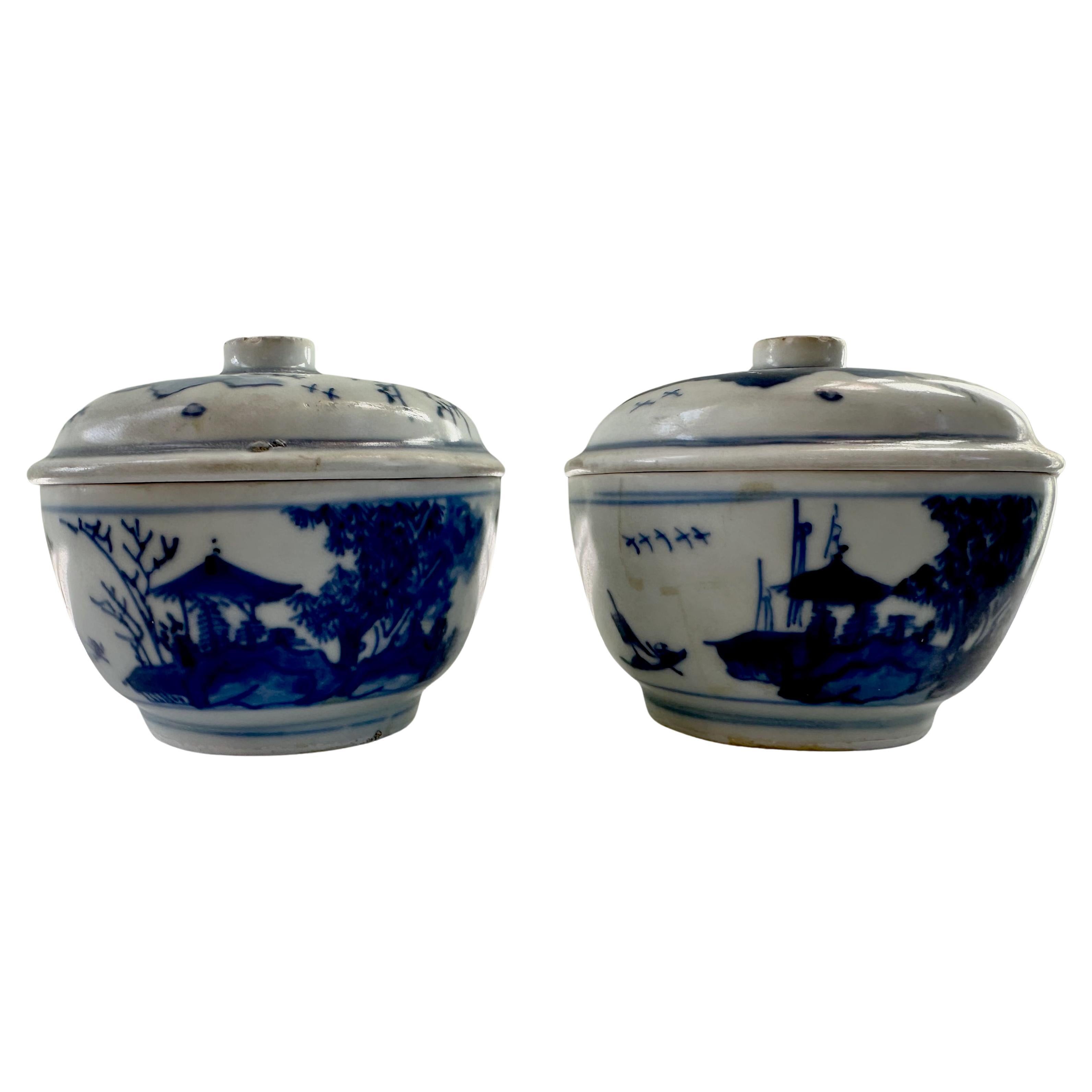 Pair of 17th Century blue and white covered bowls from the Hatcher Collection painted with a river landscape. The bowls are shaped with steeply rounded sides, painted with a continuous river landscape with two figures conversing on an island beside