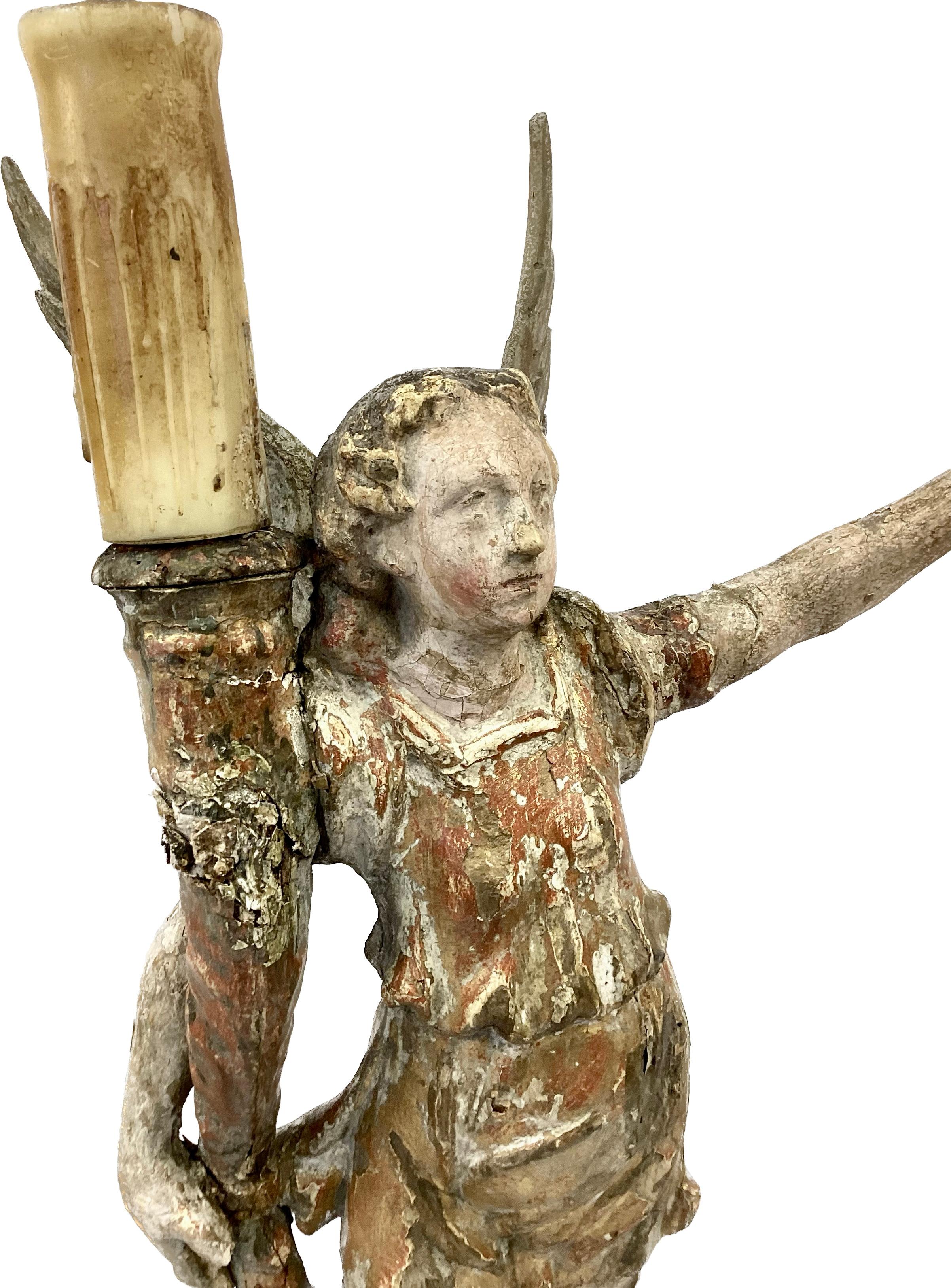 A pair of Italian gilt and painted wood figures of candle bearing angel lamps. Angels have an impressive 12 inch wingspan and each is raised on a wooden square base. Figures are classically draped and holding a cornucopia designed base for the large