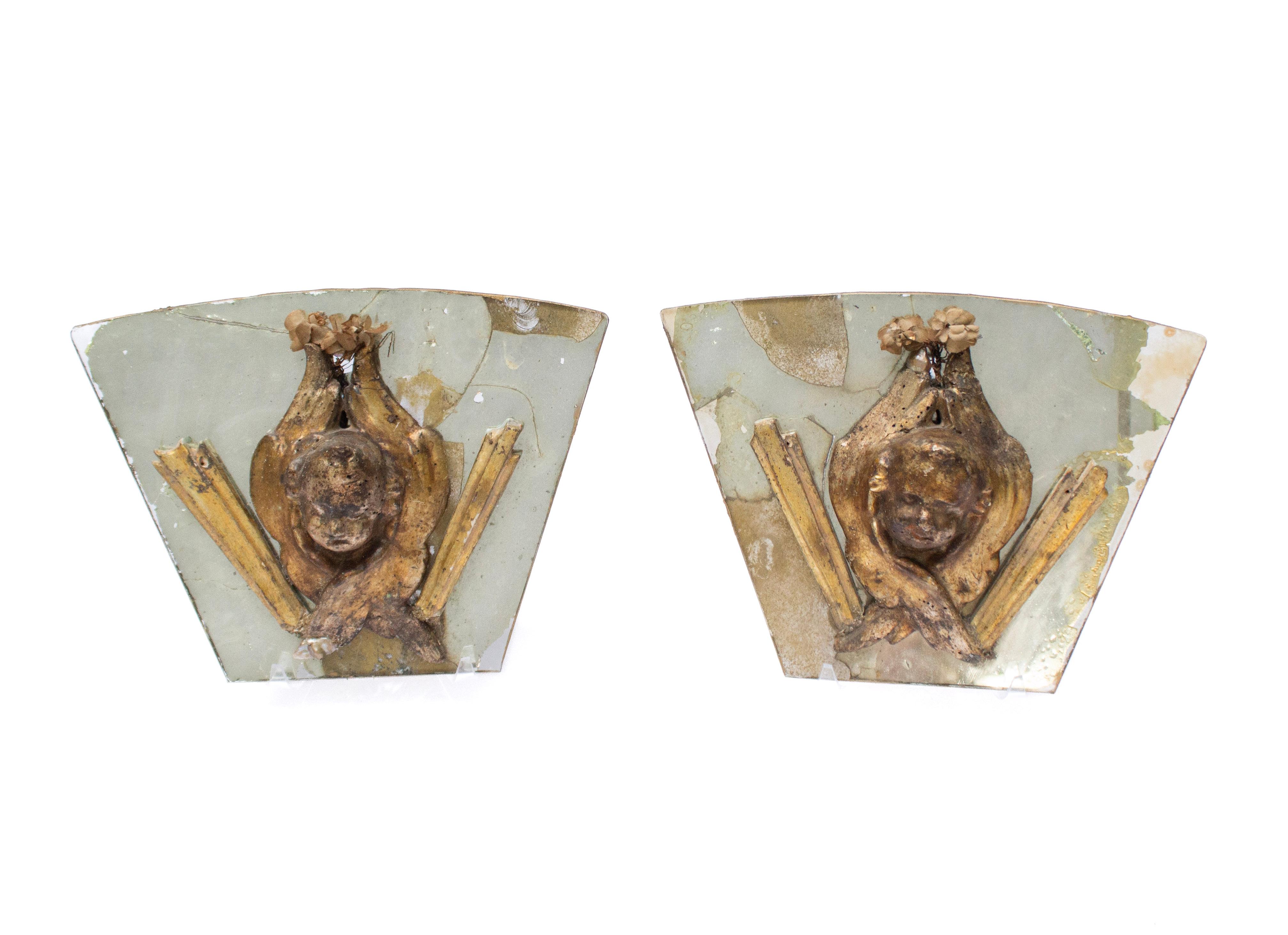 Pair of 17th century Italian wood angel heads and original textile foliage with sun-ray fragments mounted on antique mercury glass mirrors.  

Originally from a church in Tuscany, each artifact has been hand carved and naturally distressed with age.