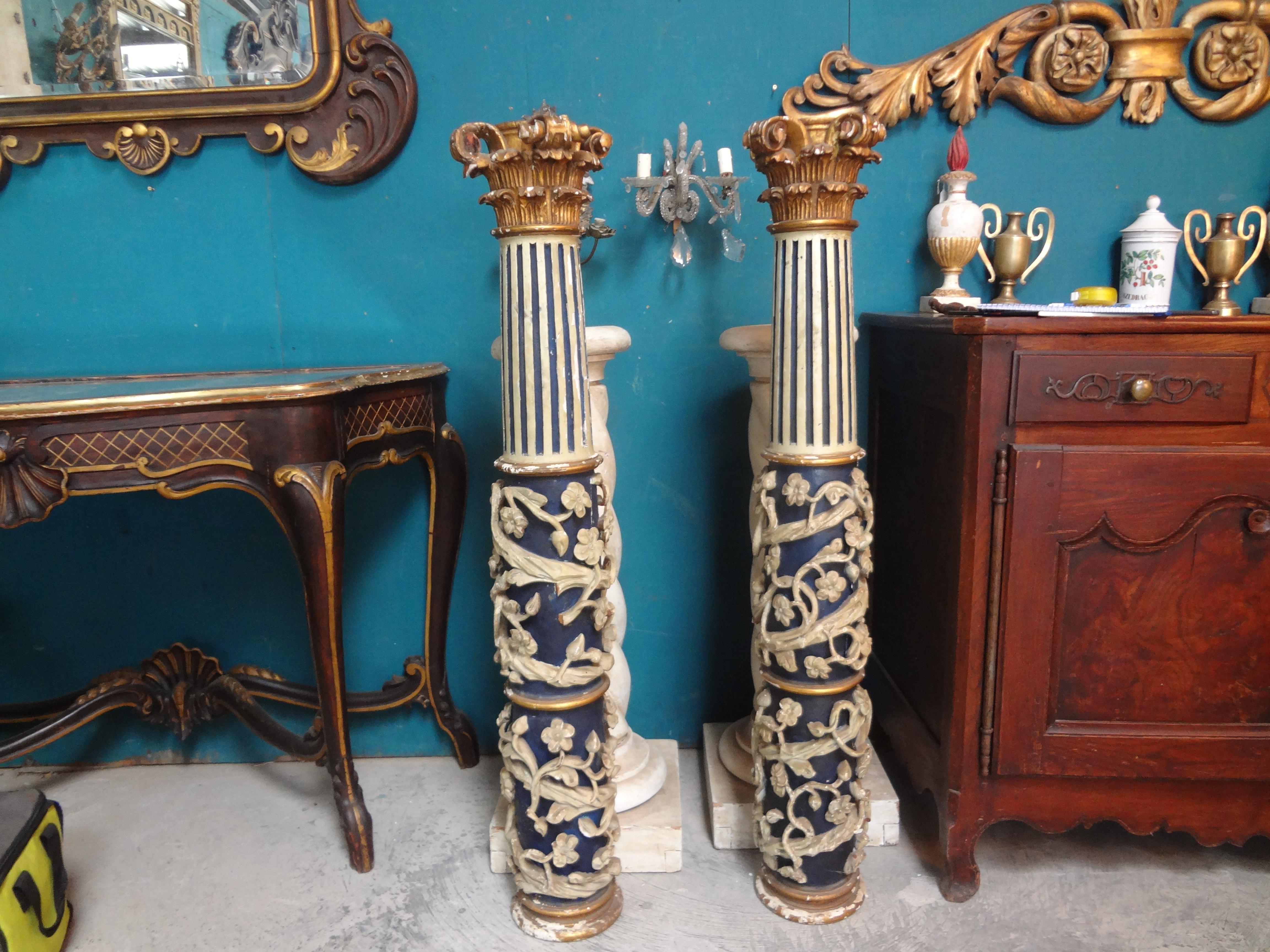 Outstanding pair of 17th century Italian Baroque hand carved columns. These stunning Italian columns are carved out of one piece of wood and have vine and flower relief decoration. They are painted a beautiful blue and cream color with a gilt