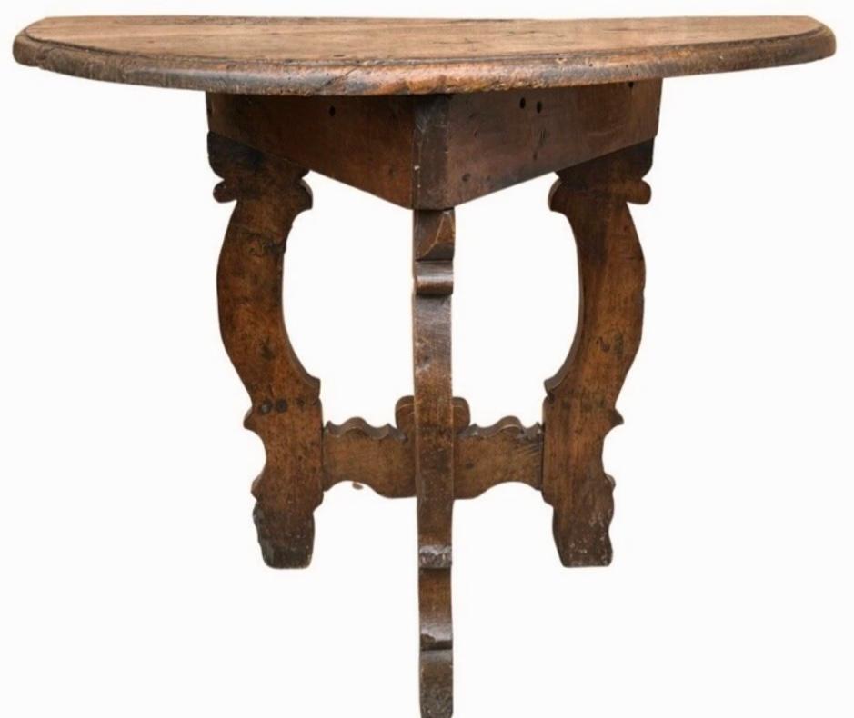 Pair of 17th century walnut console tables. The one board half round hand carved top with shaped, molded edge. The canted legs are lyre shaped and are connected to each other with a single shaped stretcher and make a very simple, but strong