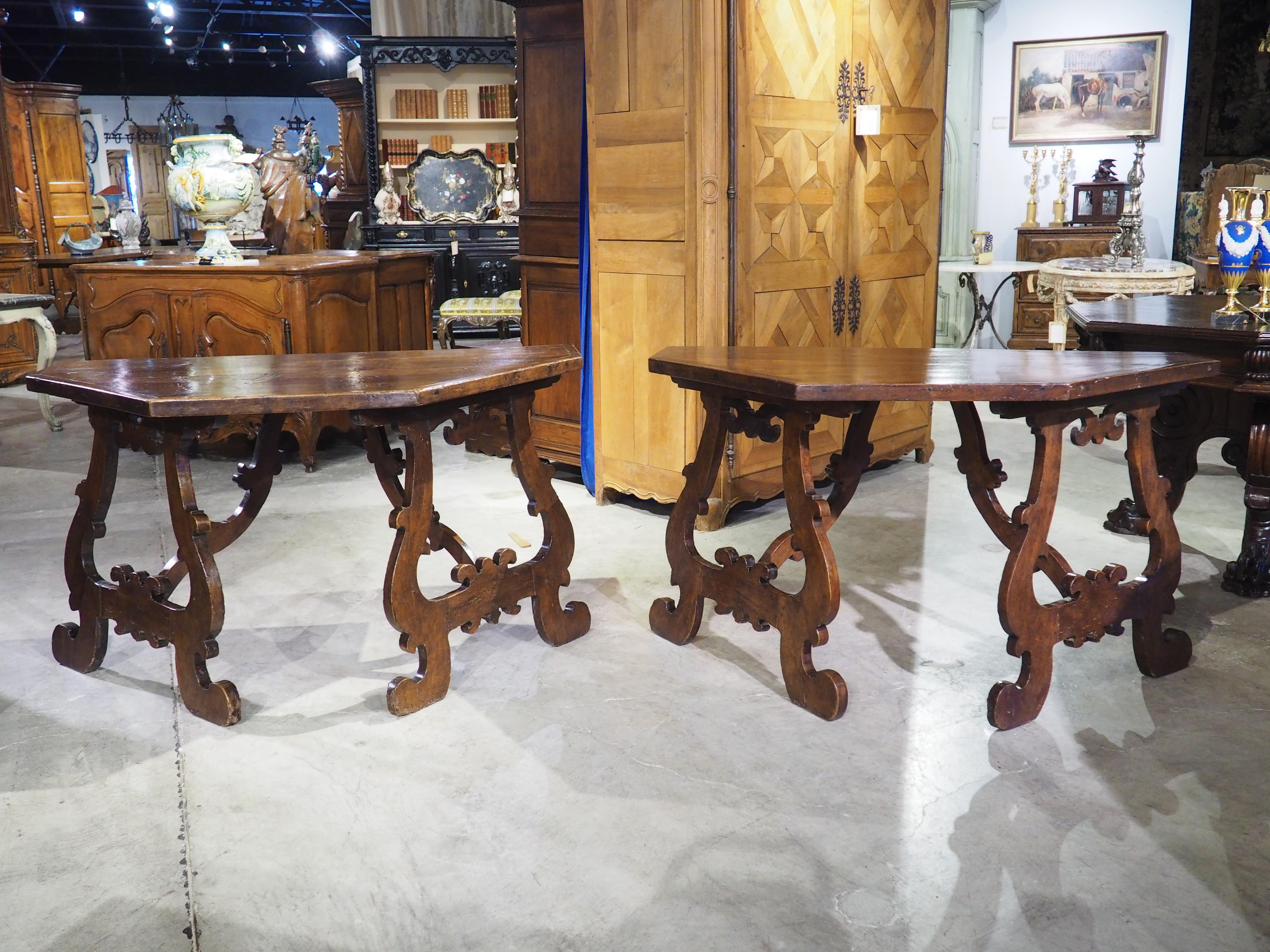 During the early stages of the Baroque period, Spanish influence began to be seen in hand-carved furniture. One such inspiration was the use of fretted lyre legs on half-round/octagonal tables, as seen in our pair of Italian consoles. These
