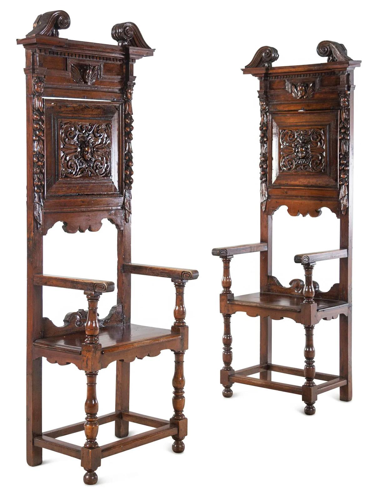 A pair of 17th century Renaissance Revival style tall-back armchairs carved from walnut with velvet seat cushions. 

Dimensions: 84