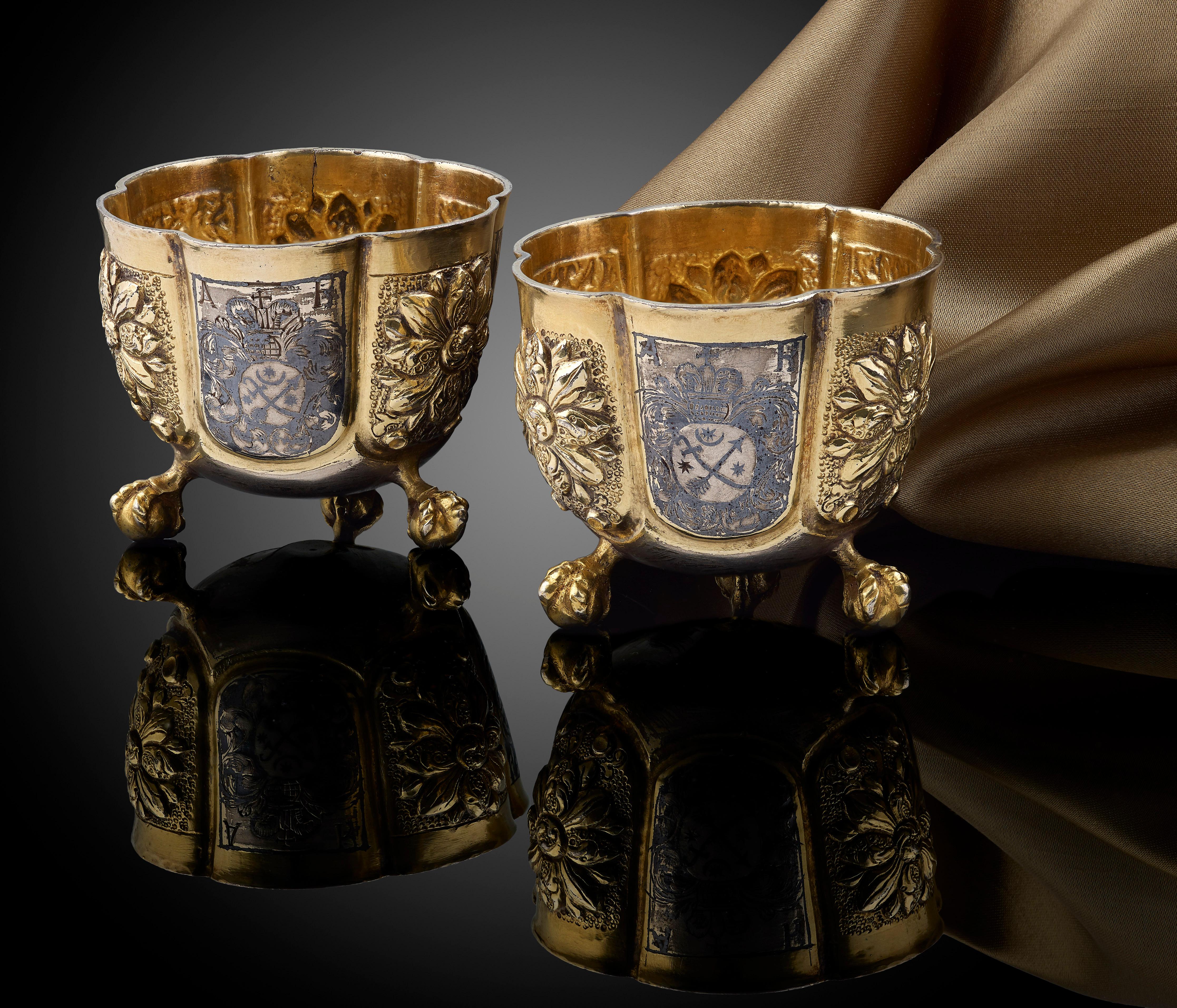 A fine and rare pair of Russian silver Vodka cups, circa 1680–1690, probably Moscow; gilded and with Niello work decorative panels; each stand on three little ball feet; inside each cup is a stamped collector's mark (which are probably 18th century